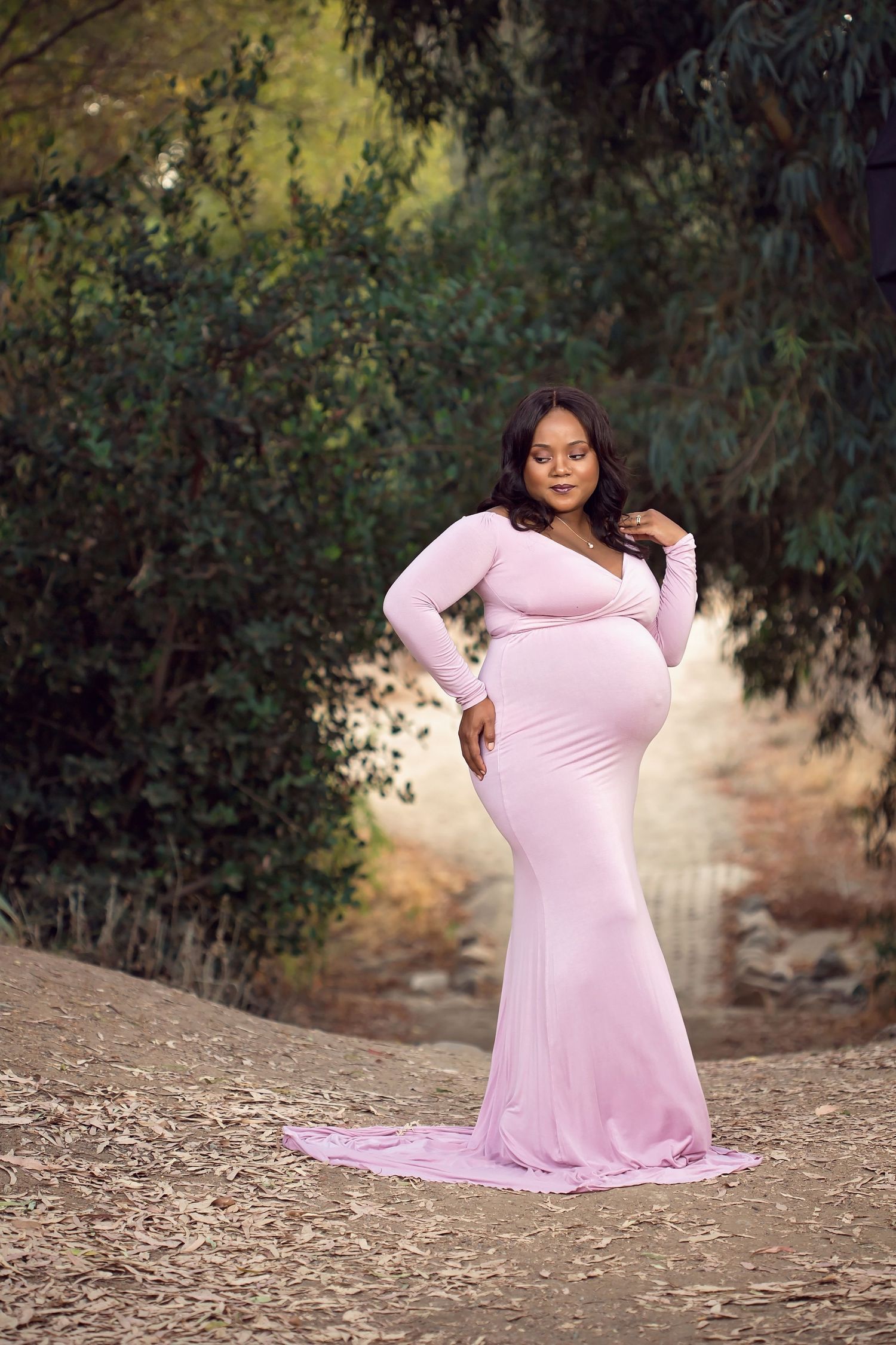 A graceful maternity photo series in a soft pink dress amidst natural surroundings. San Diego Maternity Photographer