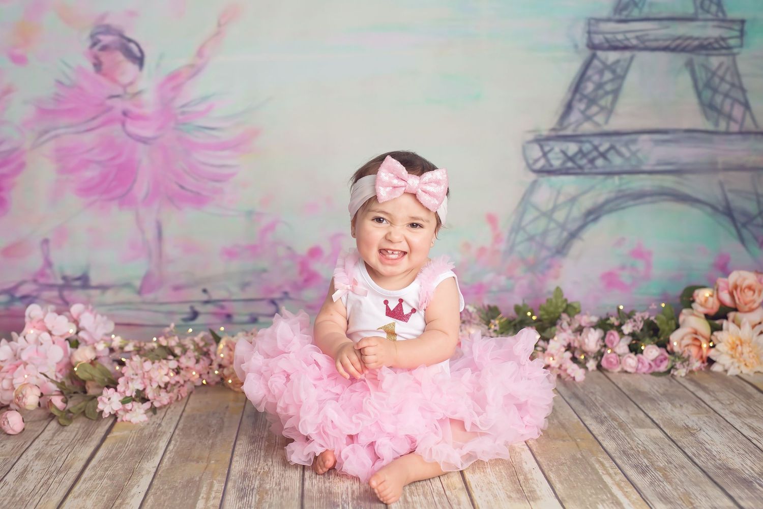 san Diego photographe A dreamy pink and purple Paris-themed backdrop with Eiffel Tower props and floral decorations in a photo studio setup.