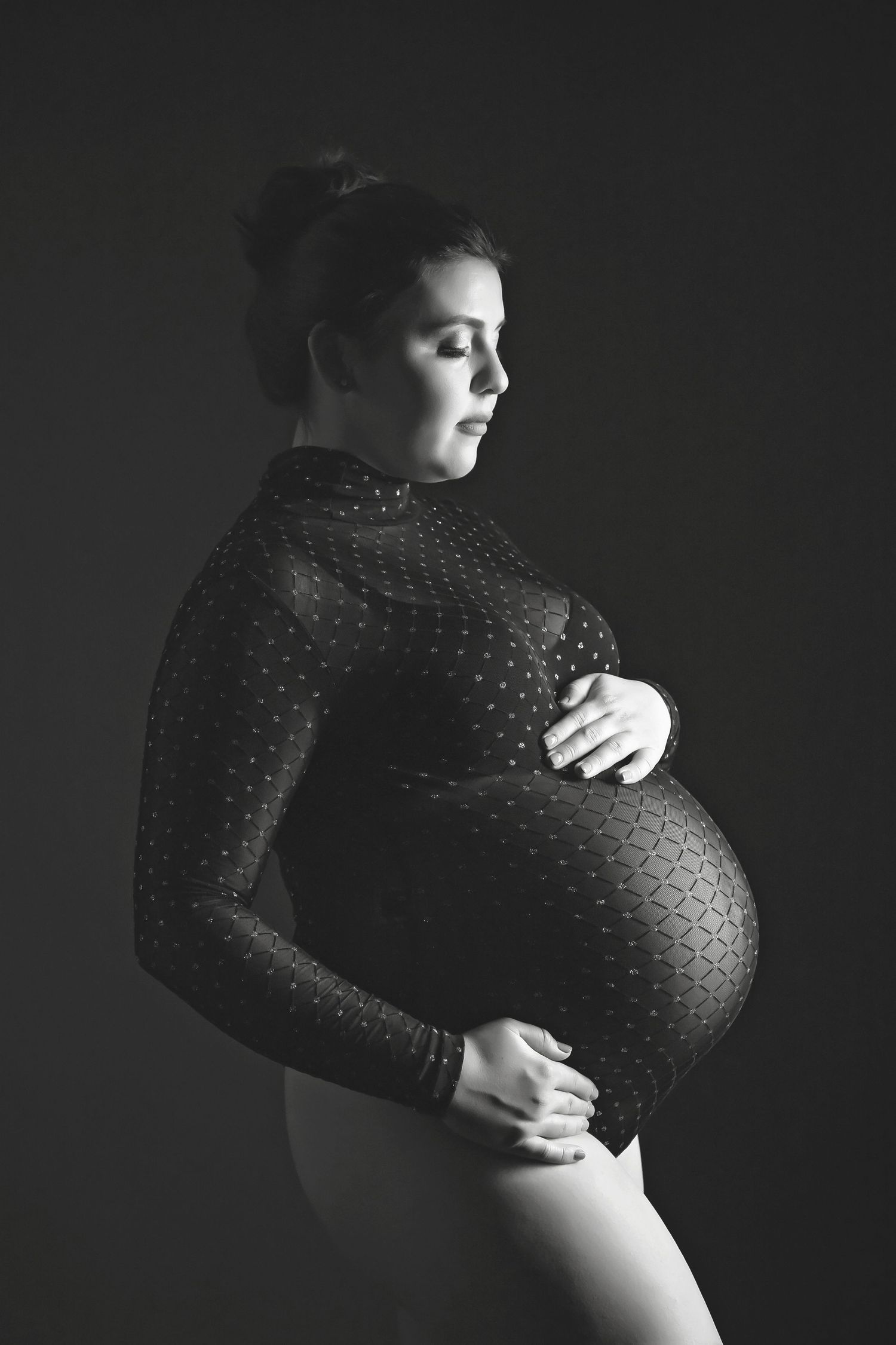 Artistic black and white maternity portrait emphasizing natural curves