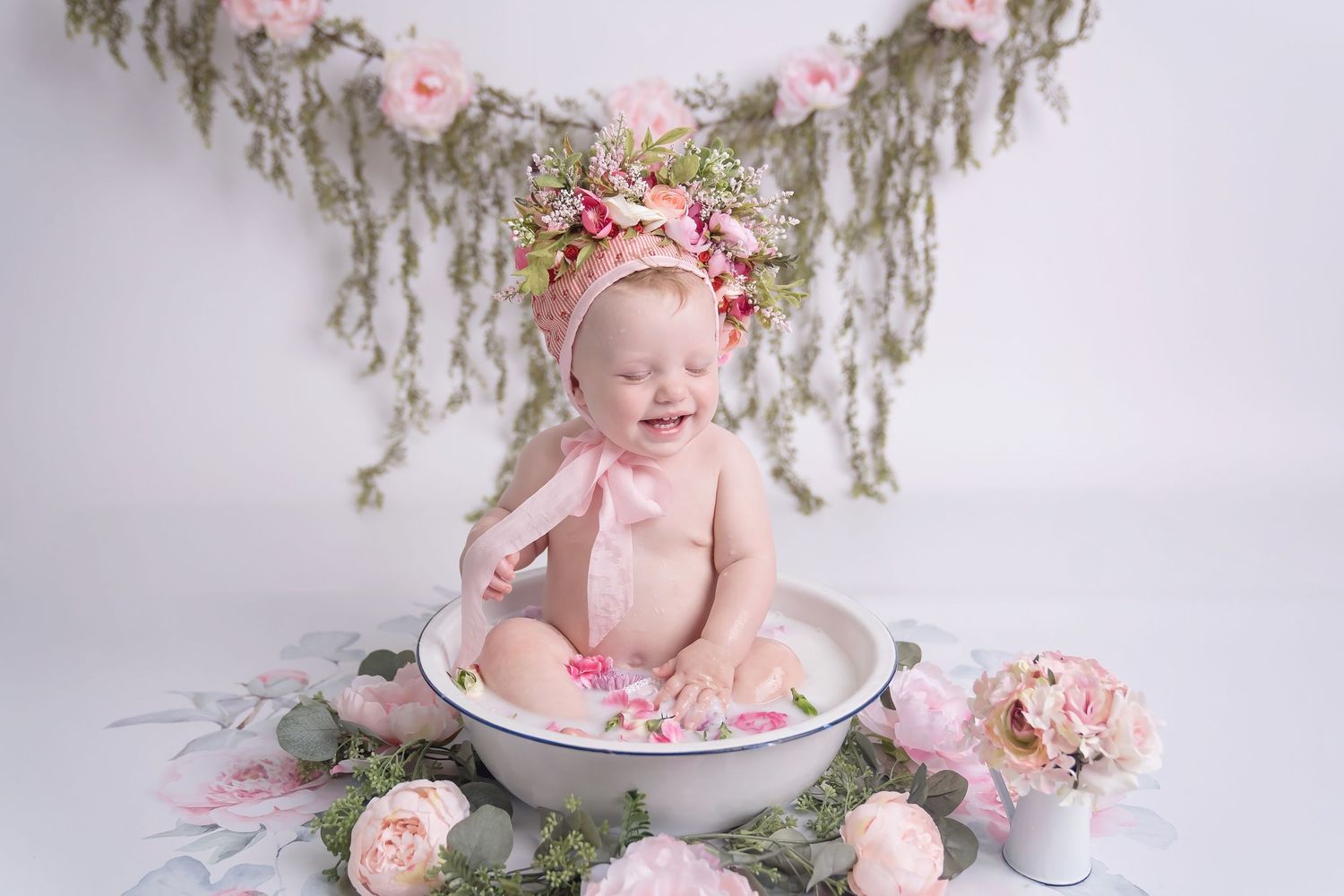 San Diego cake smash photo in Dreamy white and pink bath setup with flowers and vintage decor for baby photos.