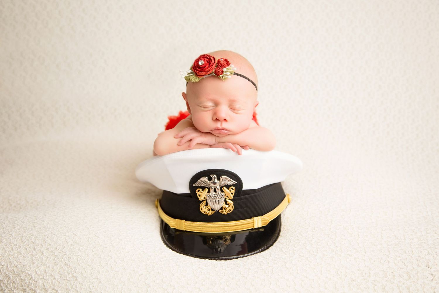 Sleeping newborn baby posed with military officer's cap in patriotic themed photoshoot. San Diego Newborn Photographer