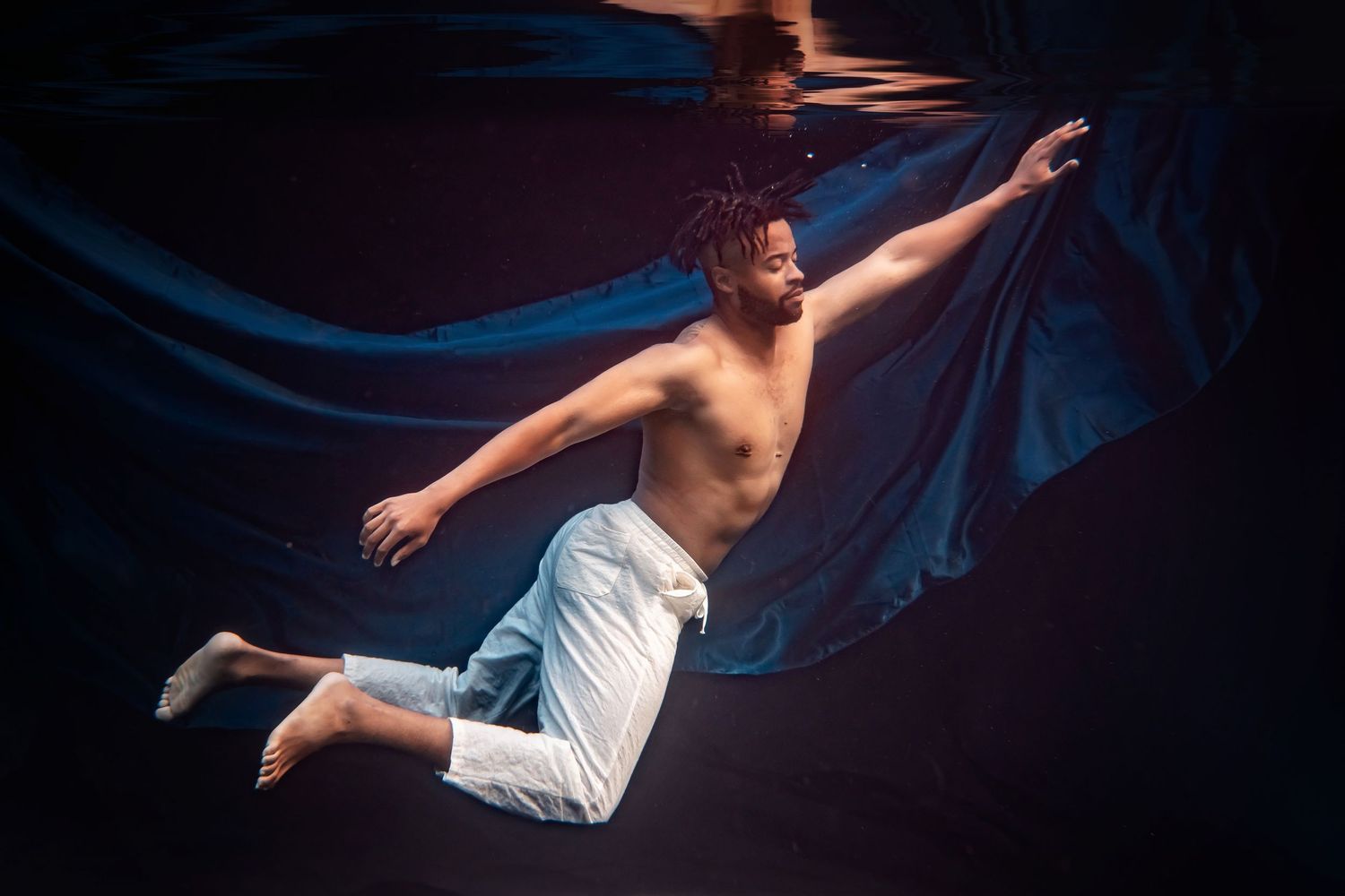 Graceful underwater portrait with flowing fabric and rising bubbles