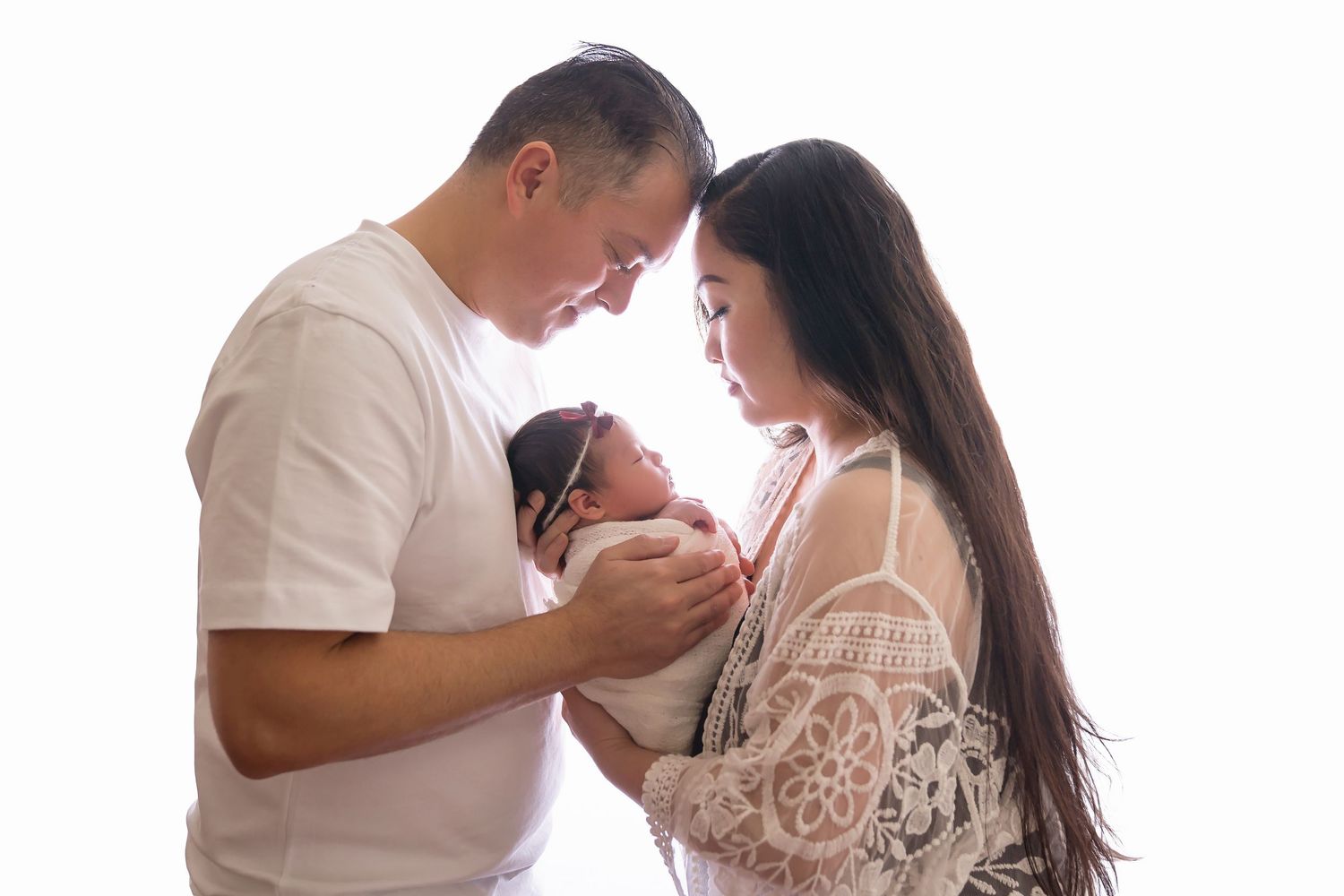 Intimate maternity portrait session with couple in white against neutral background. San Diego Newborn Photographer