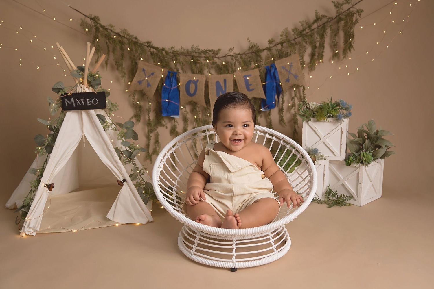Rustic photography setup with teepee tents and greenery decorations.