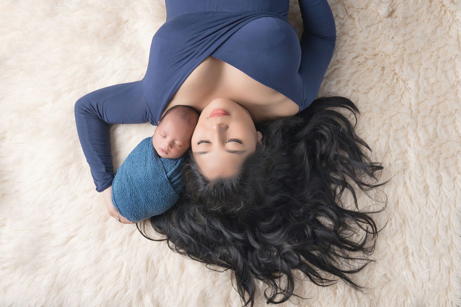 Artistic maternity portrait with flowing navy fabric against white background. San Diego Newborn Photographer