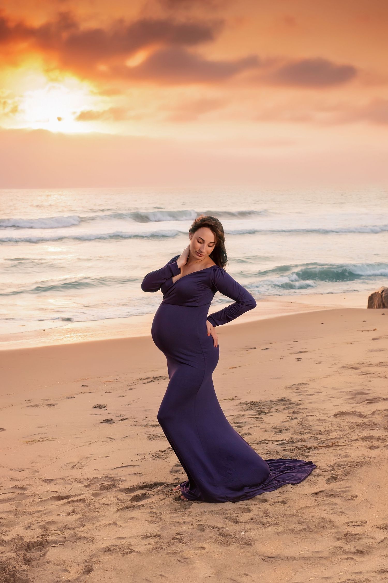 Maternity photos on sandy beach with dramatic orange sunset sky. San Diego Maternity Photographer