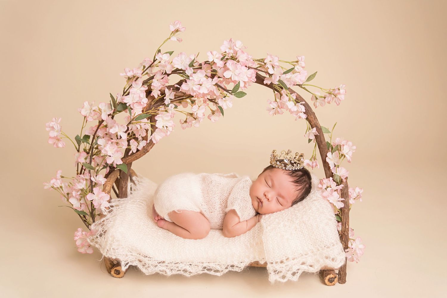 Artistic newborn portrait with pink cherry blossoms and white bedding. San Diego Newborn Photographer