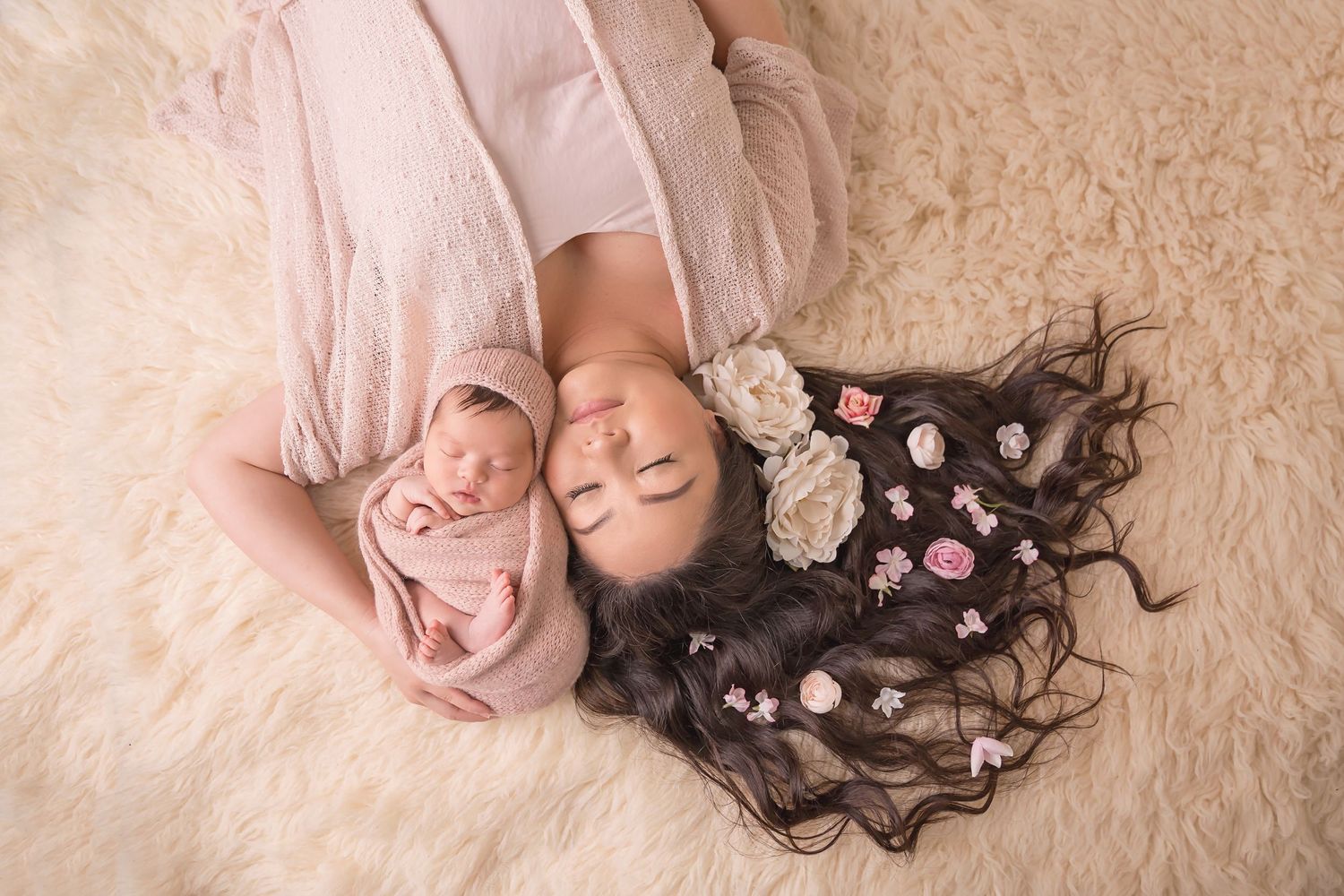 Artistic newborn photography with flowers and soft textured backdrop in neutral tones. San Diego Newborn Photographer