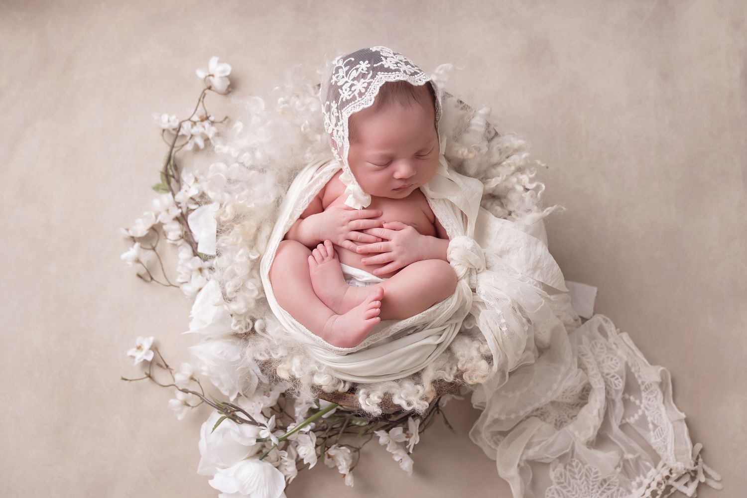 San Diego newborn photographer captures Newborn baby sleeping in vintage lace and floral decorations with neutral backdrop.
