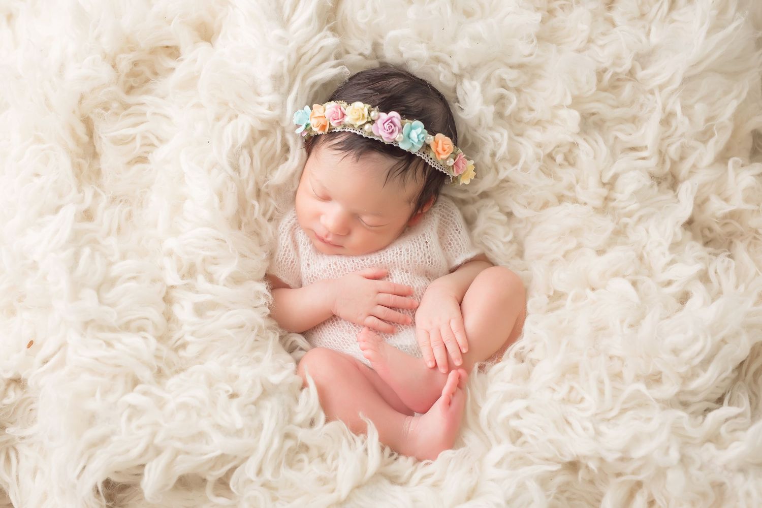 Newborn baby sleeping peacefully on soft cream colored textured blanket. San Diego Newborn Photographer