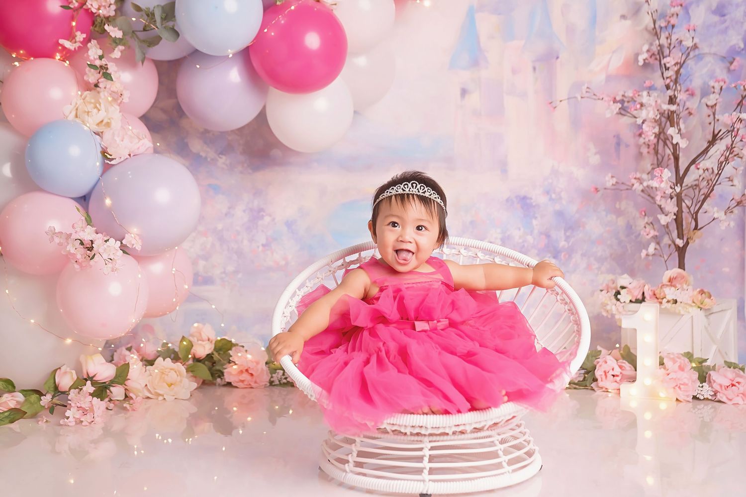San Diego Cake Smash Princess theme with Festive pink and white balloon backdrop with white wicker chair and cherry blossom decorations.