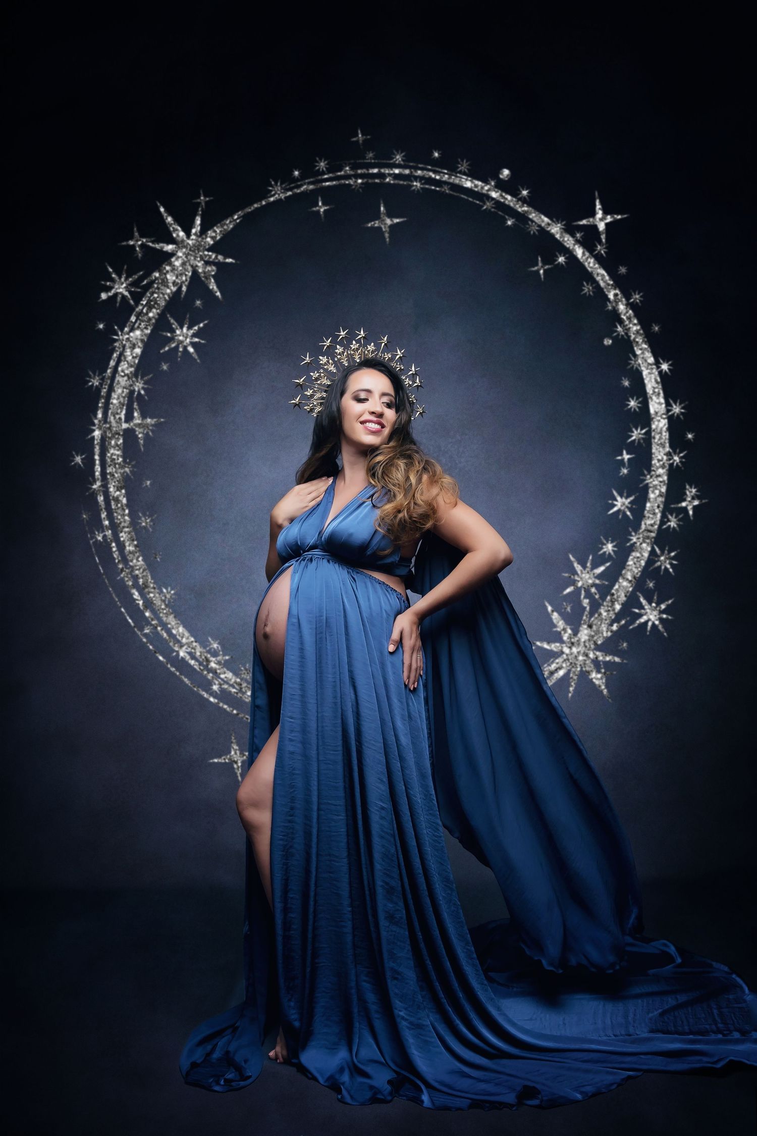 Celestial maternity portrait with star décor and flowing blue gown