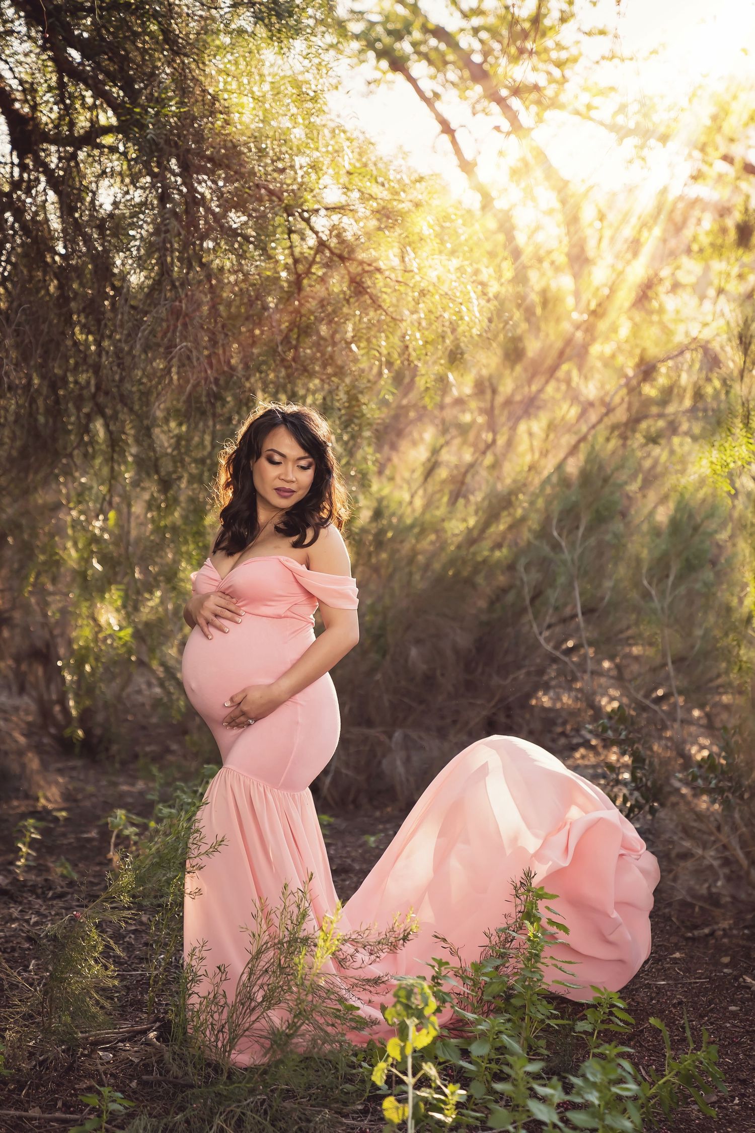 Romantic maternity photos in pink dress with sunlit natural backdrop. San Diego Maternity Photographer