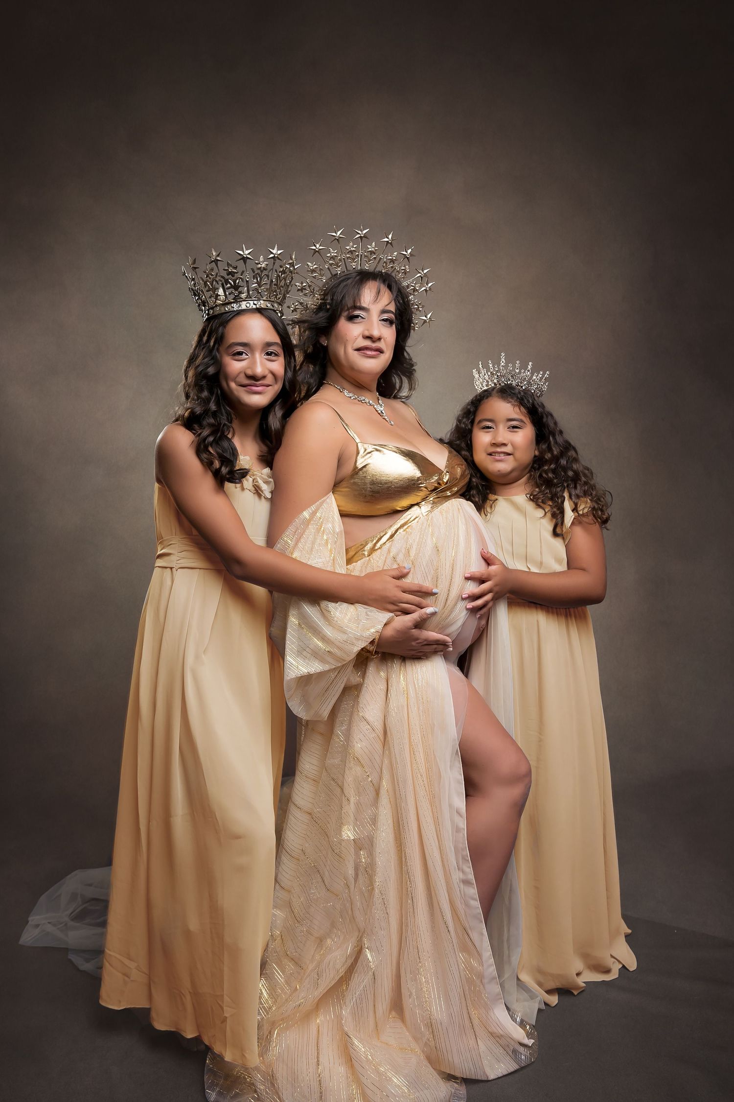 Coordinated group maternity portrait in cream dresses with crystal crowns
