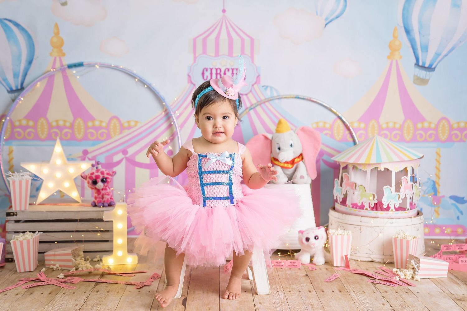 San Diego Cake Smash with Whimsical circus themed backdrop with pink tents and carnival decorations. San Diego cake smash photographer