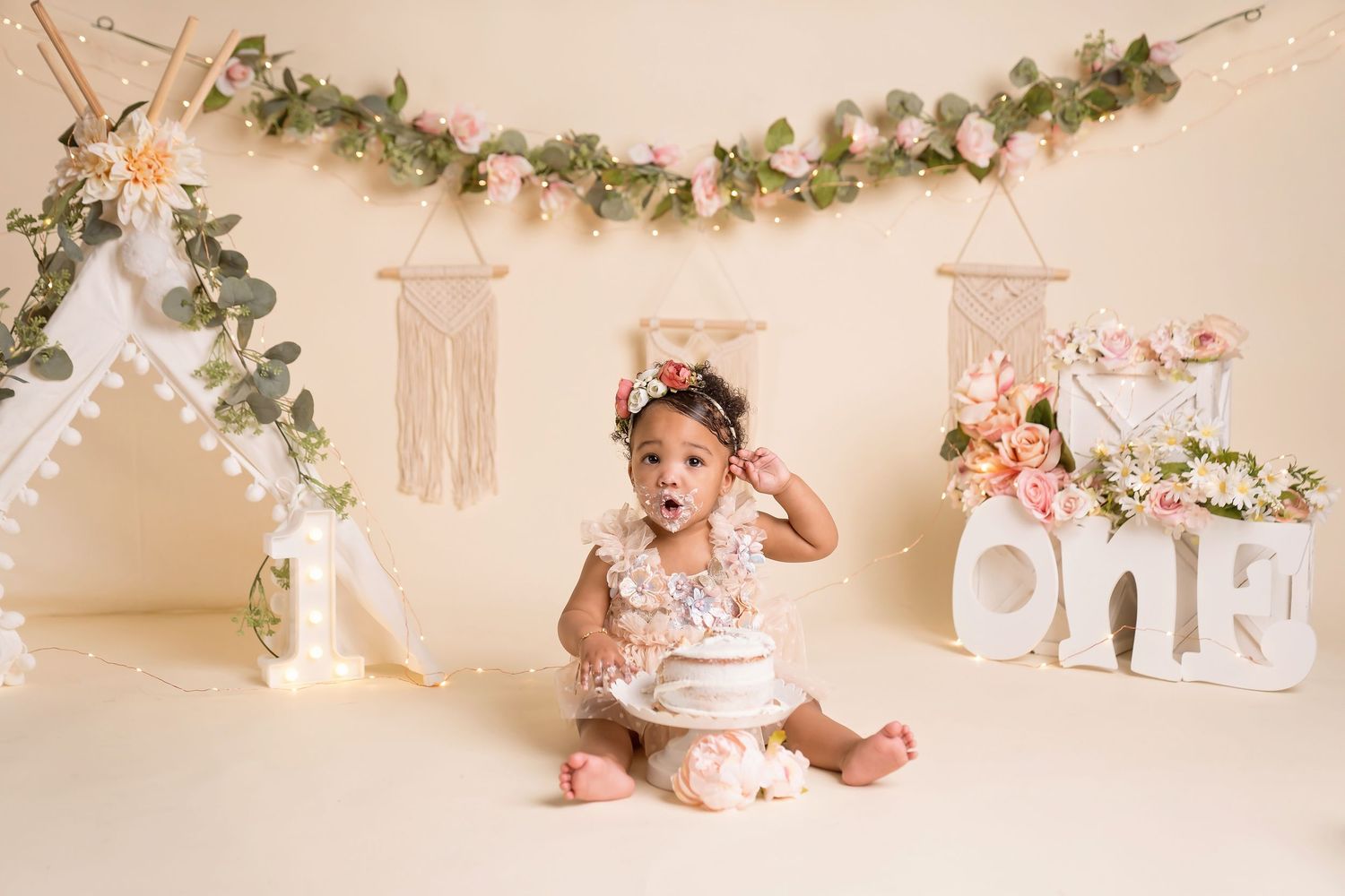 Dreamy photography setup featuring floral garlands, string lights and delicate white decor elements.