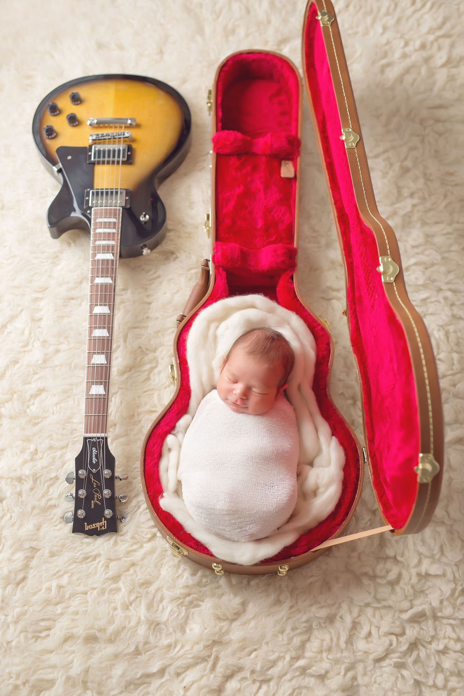 Creative newborn photography using guitar case as prop with electric guitar display. San Diego Newborn Photographer