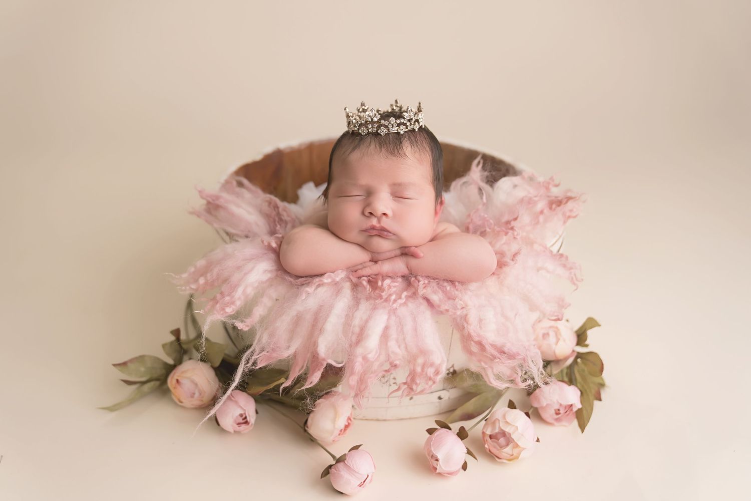 Baby sleeping among pink flowers and feathers in soft romantic setting. San Diego Newborn Photographer