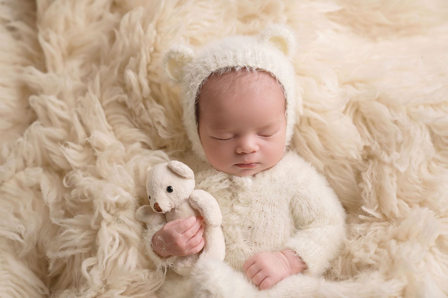 Peaceful newborn photography on soft cream textured blanket. San Diego Newborn Photographer