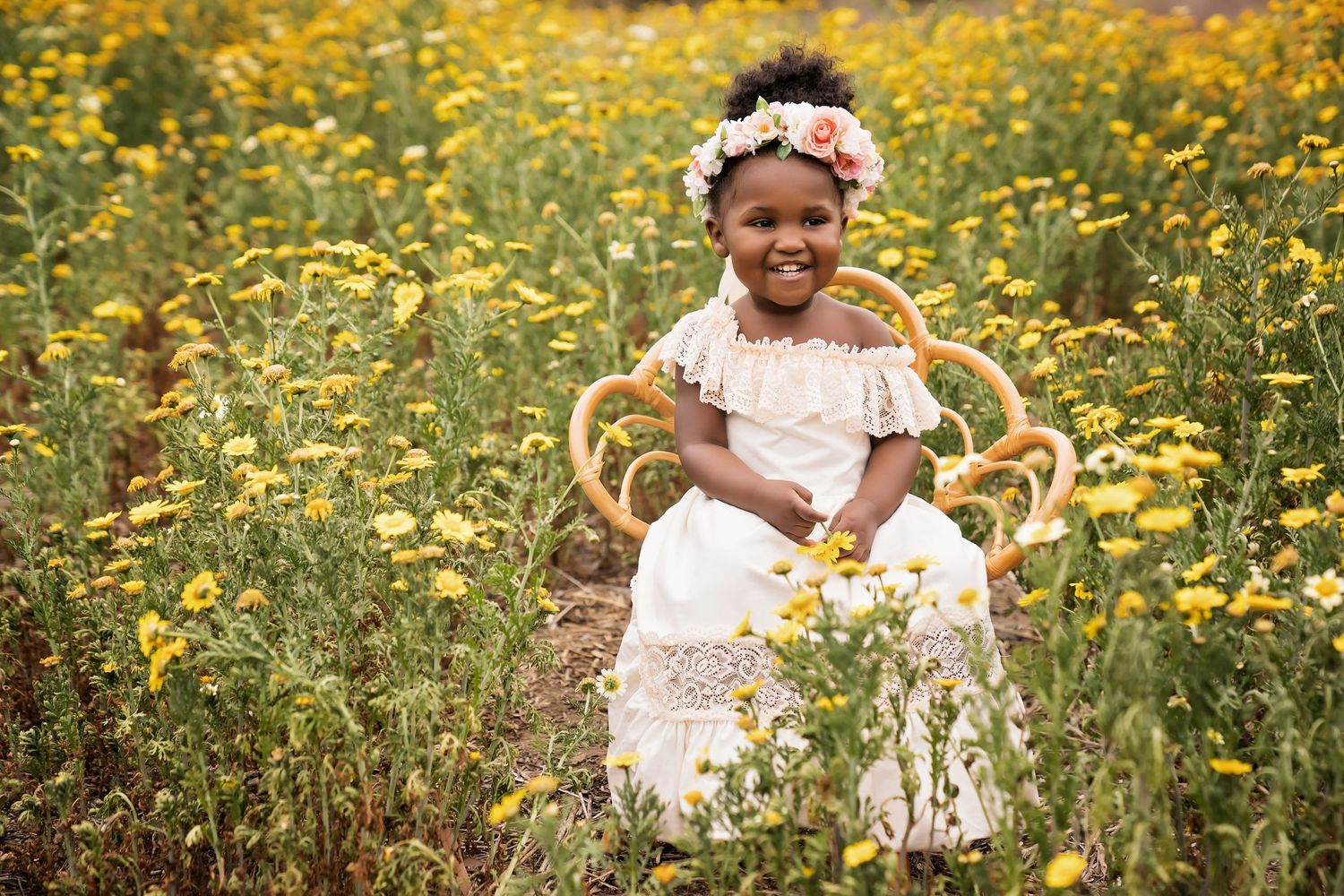 Children in white dresses playing among bright yellow wildflowers in a sunny field — San Diego outdoor session