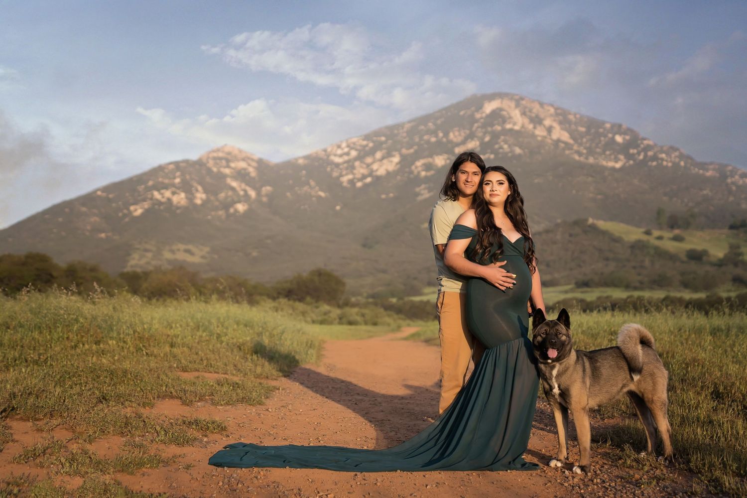 maternity photo of couple in a san diego Scenic mountain landscape with a winding dirt path during golden hour.