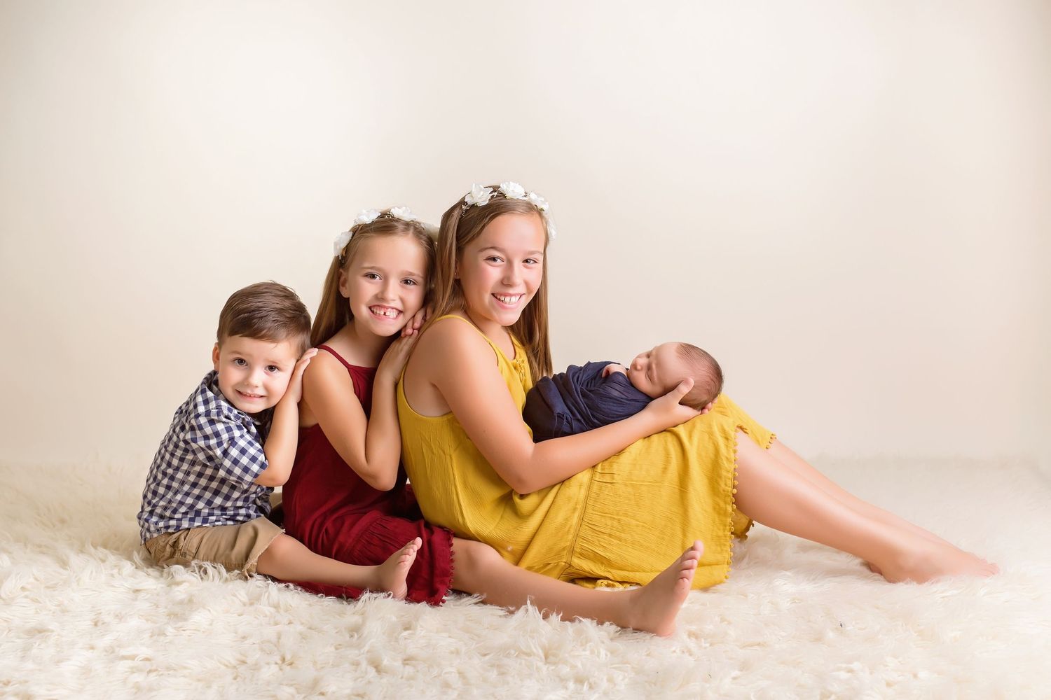 Family members lying together on cream colored rug during casual portrait session. San Diego Newborn Photographer
