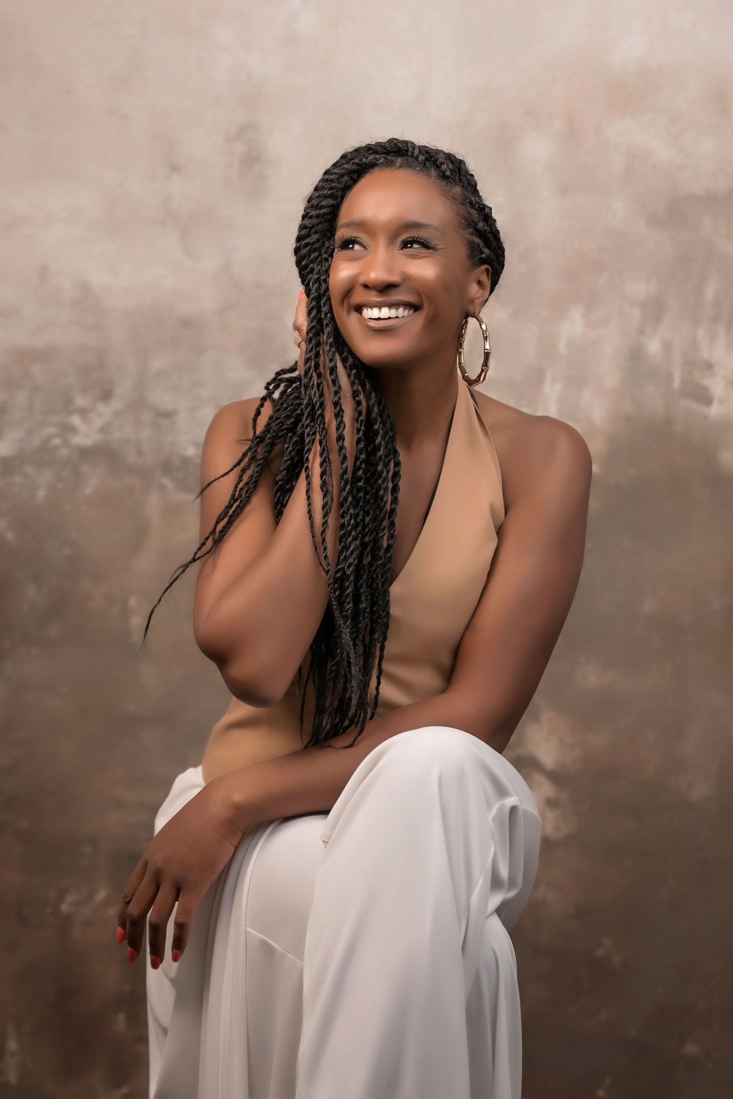 Artistic portrait of woman draped in white fabric against textured brown background