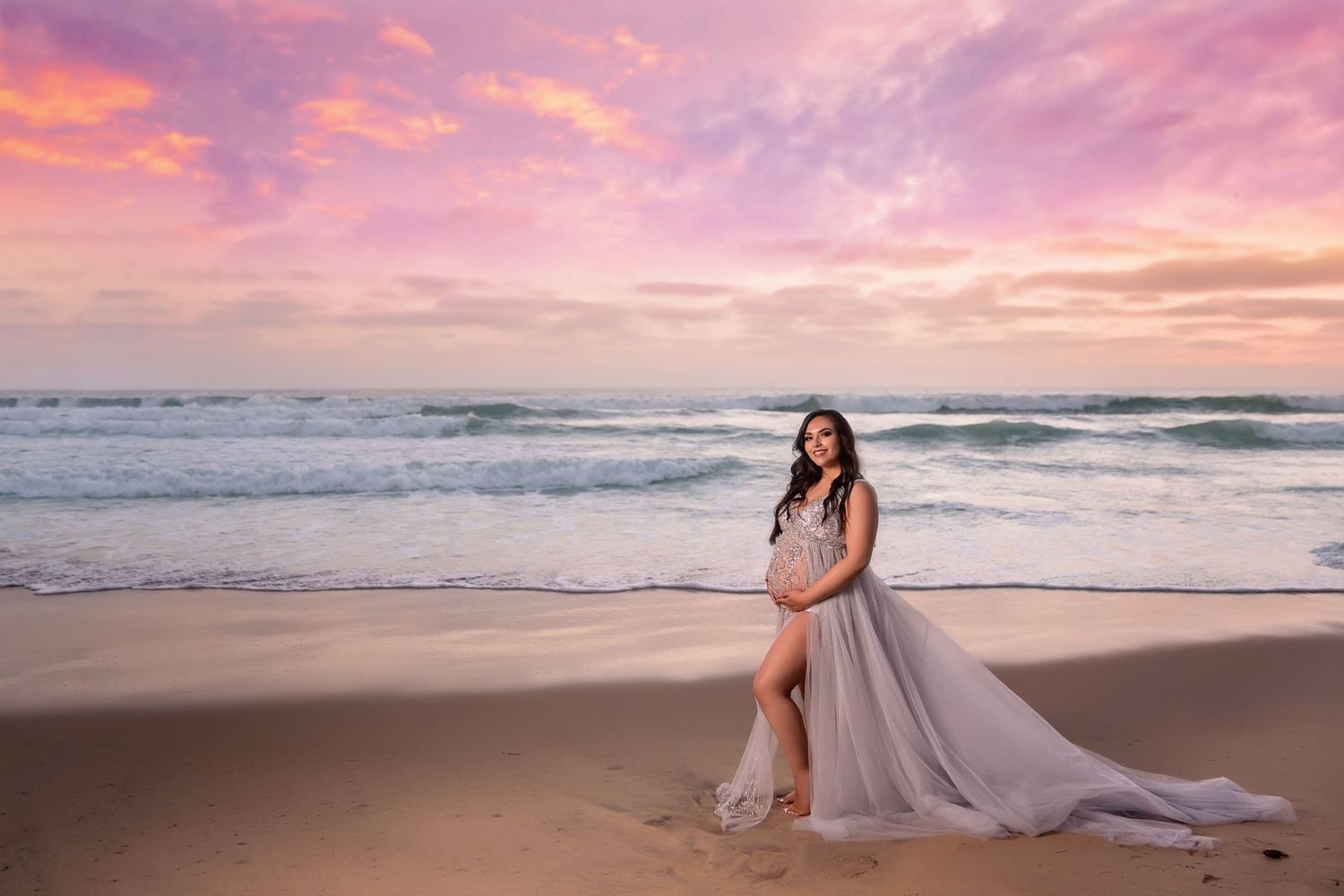 Ethereal beach maternity  portraits with flowing dress against pink and purple sunset sky. San Diego Maternity Photographer