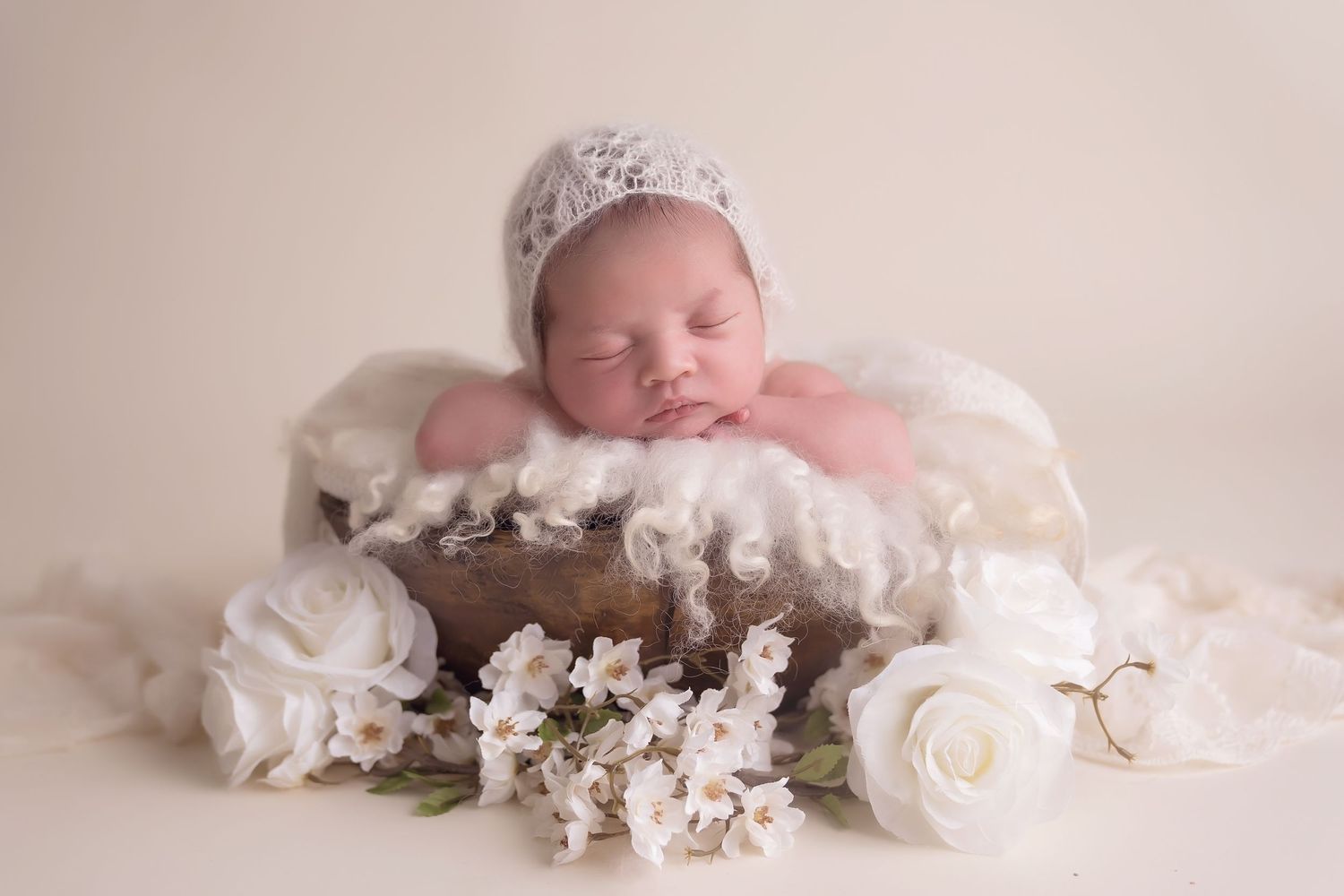 Newborn photography series with white floral decorations and delicate crown accessories. San Diego Newborn Photographer