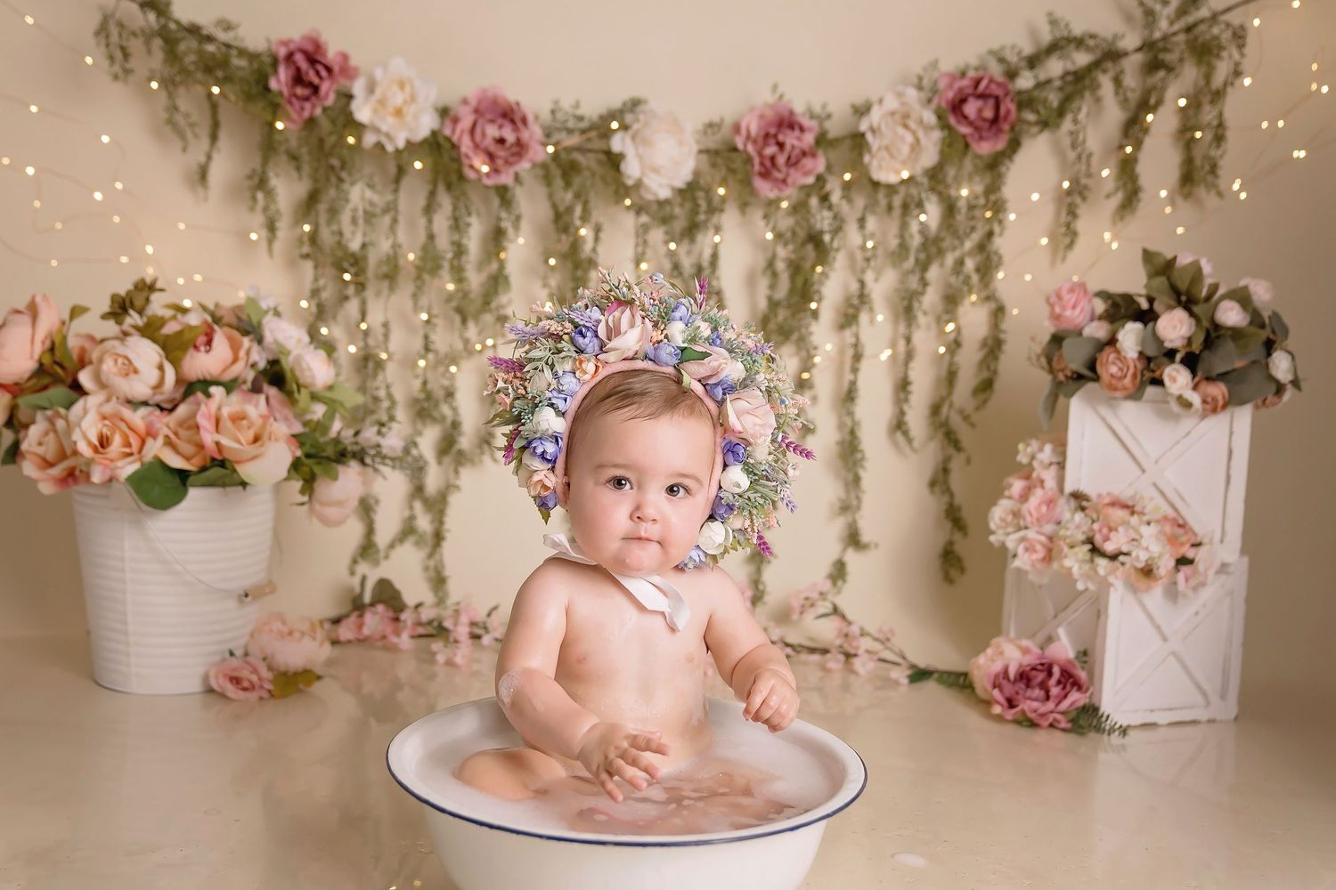 San Diego Cake Smash Session with whimsical photo backdrop with cascading flowers and twinkling lights.