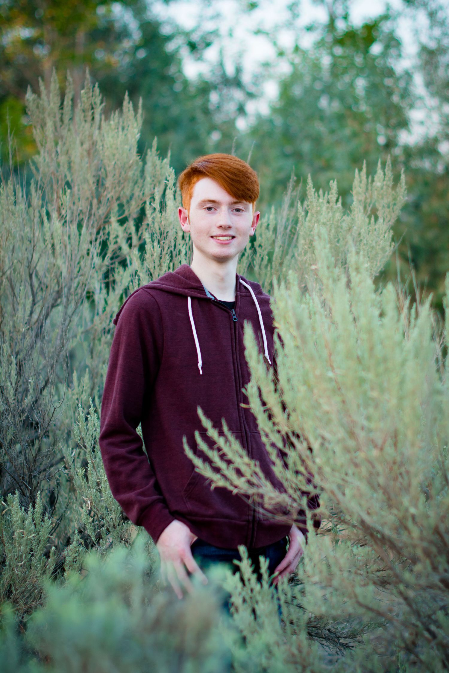 Youth portrait session among sage brush in natural outdoor setting.
