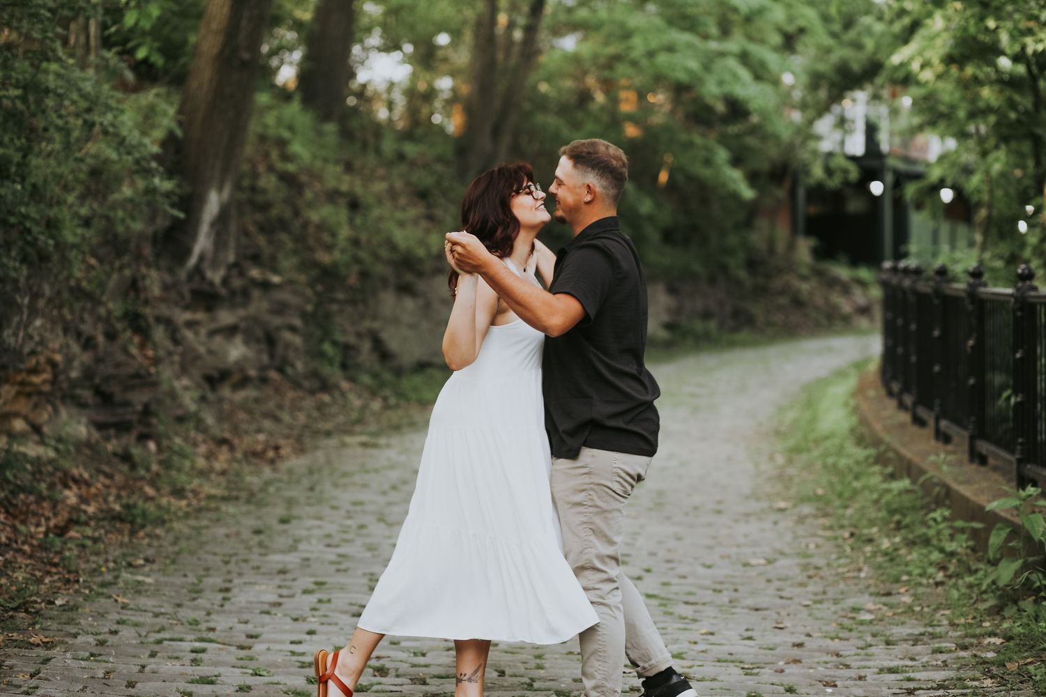 Engagement photoshoot for lovely couple dancing on a cobblestone road.