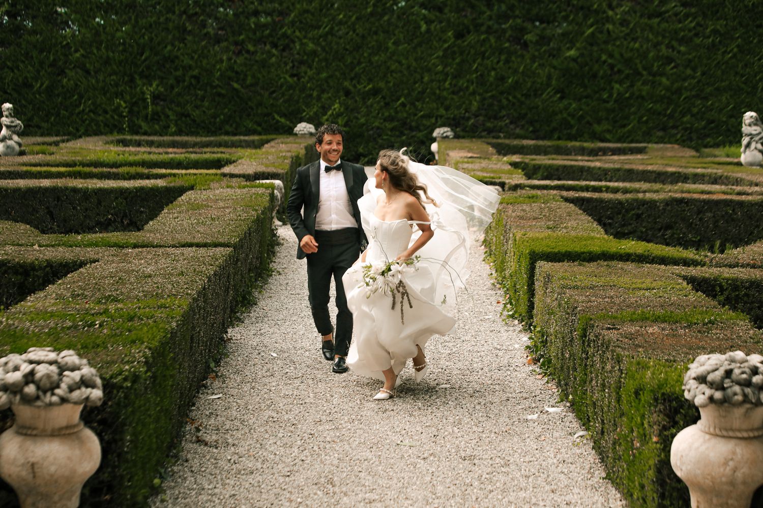 Couple photographed running through the garden after wedding.