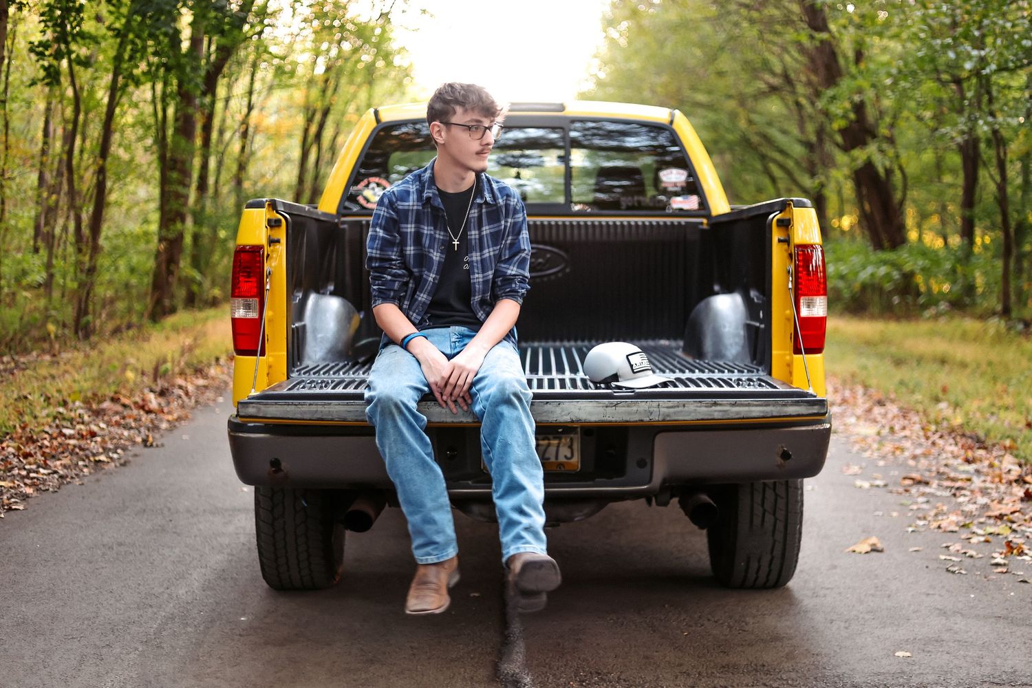 senior portrait of young man with yellow truck