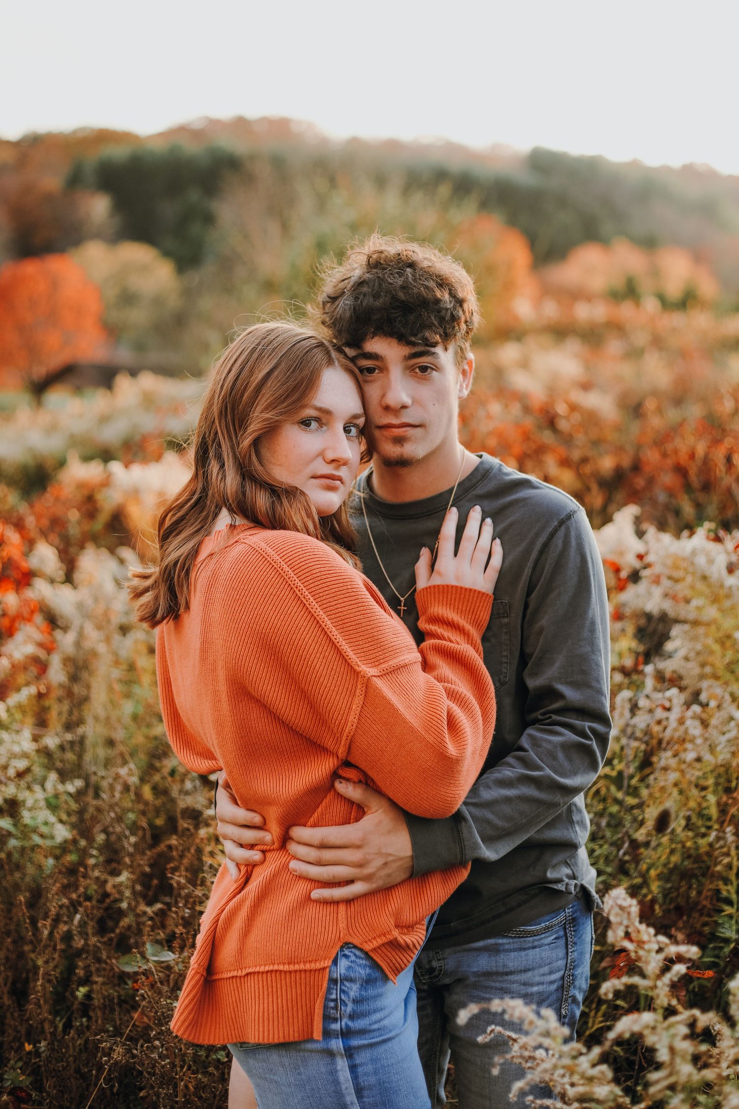 Young couple posing in a field.