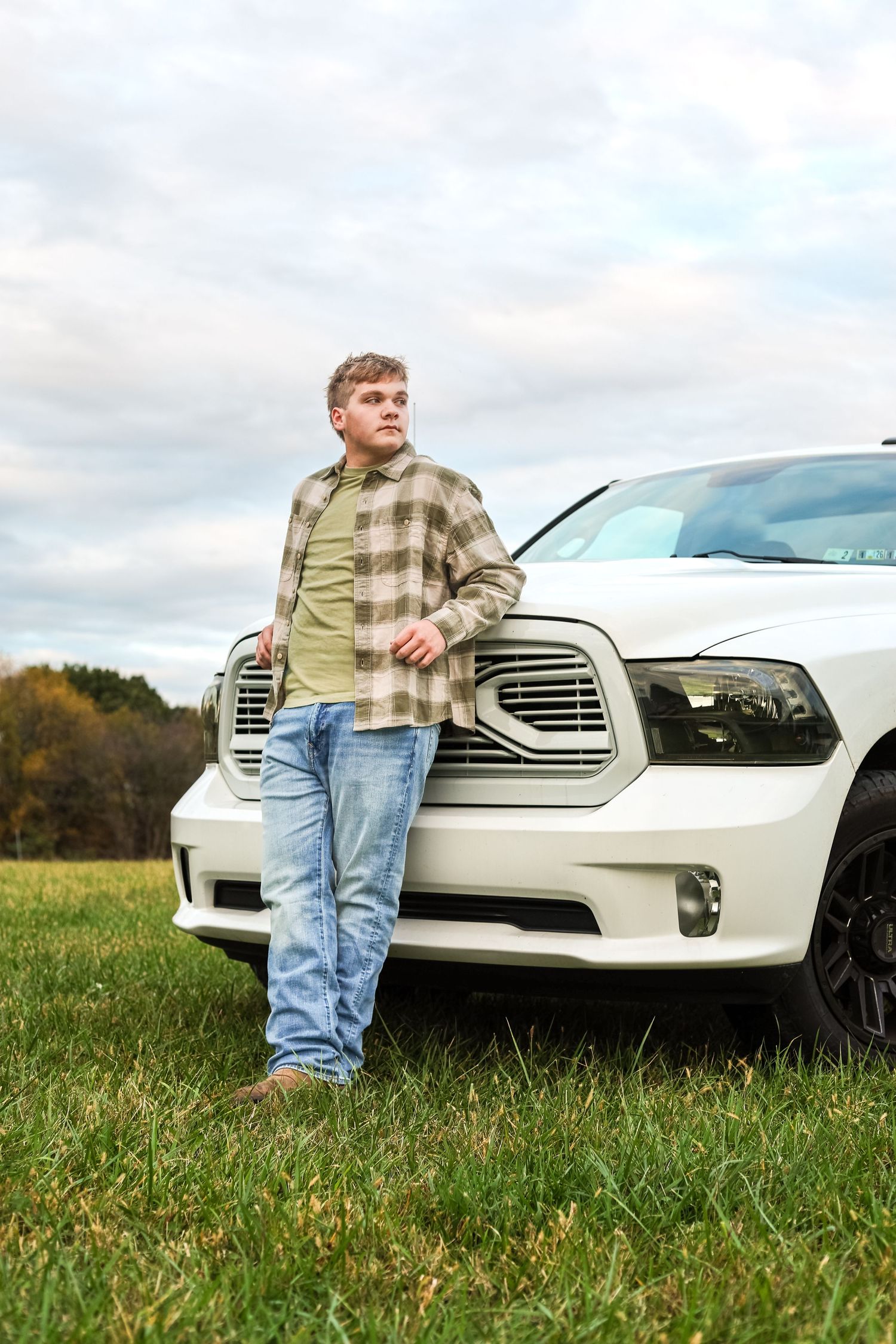 young man senior portrait taken with white truck