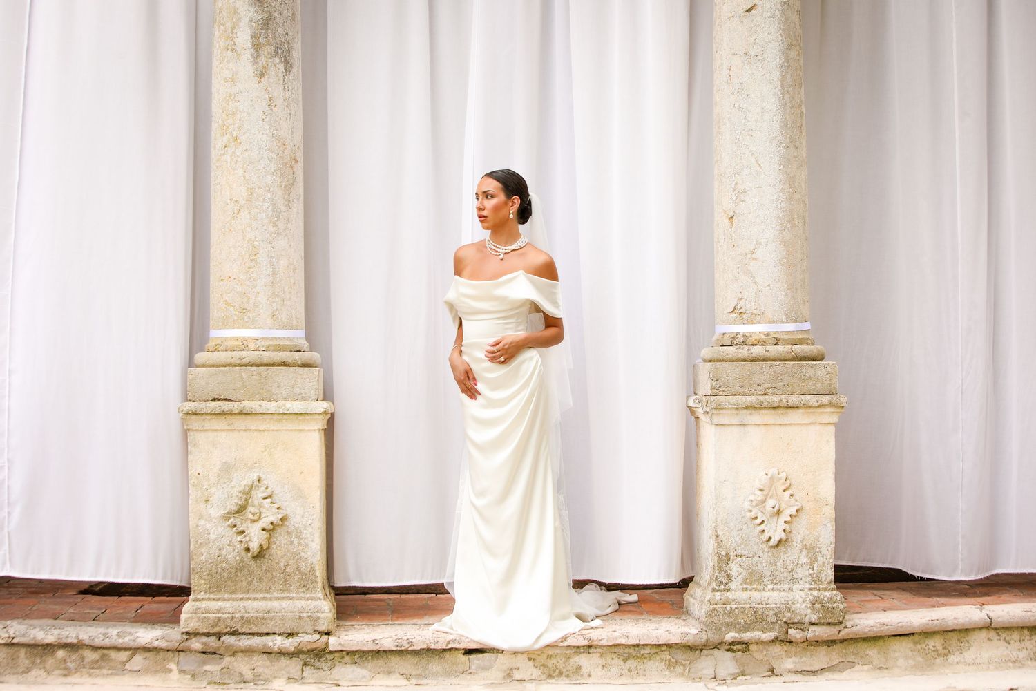 Beautiful bride poses at gorgeous villa for wedding photographer.