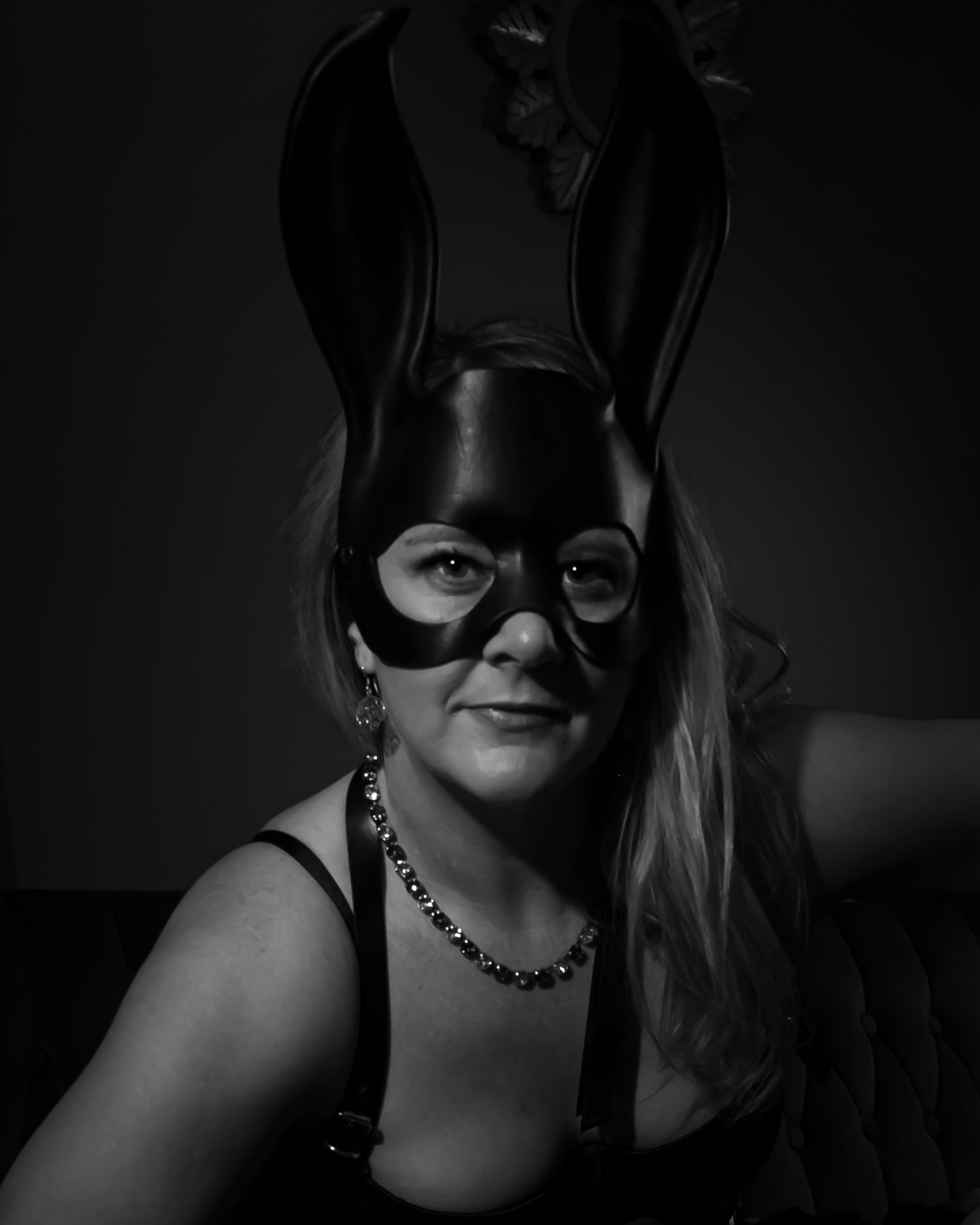 Black and white photo of a boudoir model in a black bunny mask