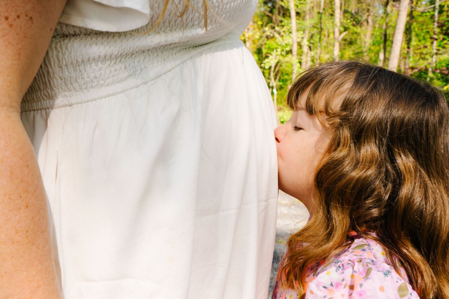 A touching moment between mother and child with a white dress in focus.