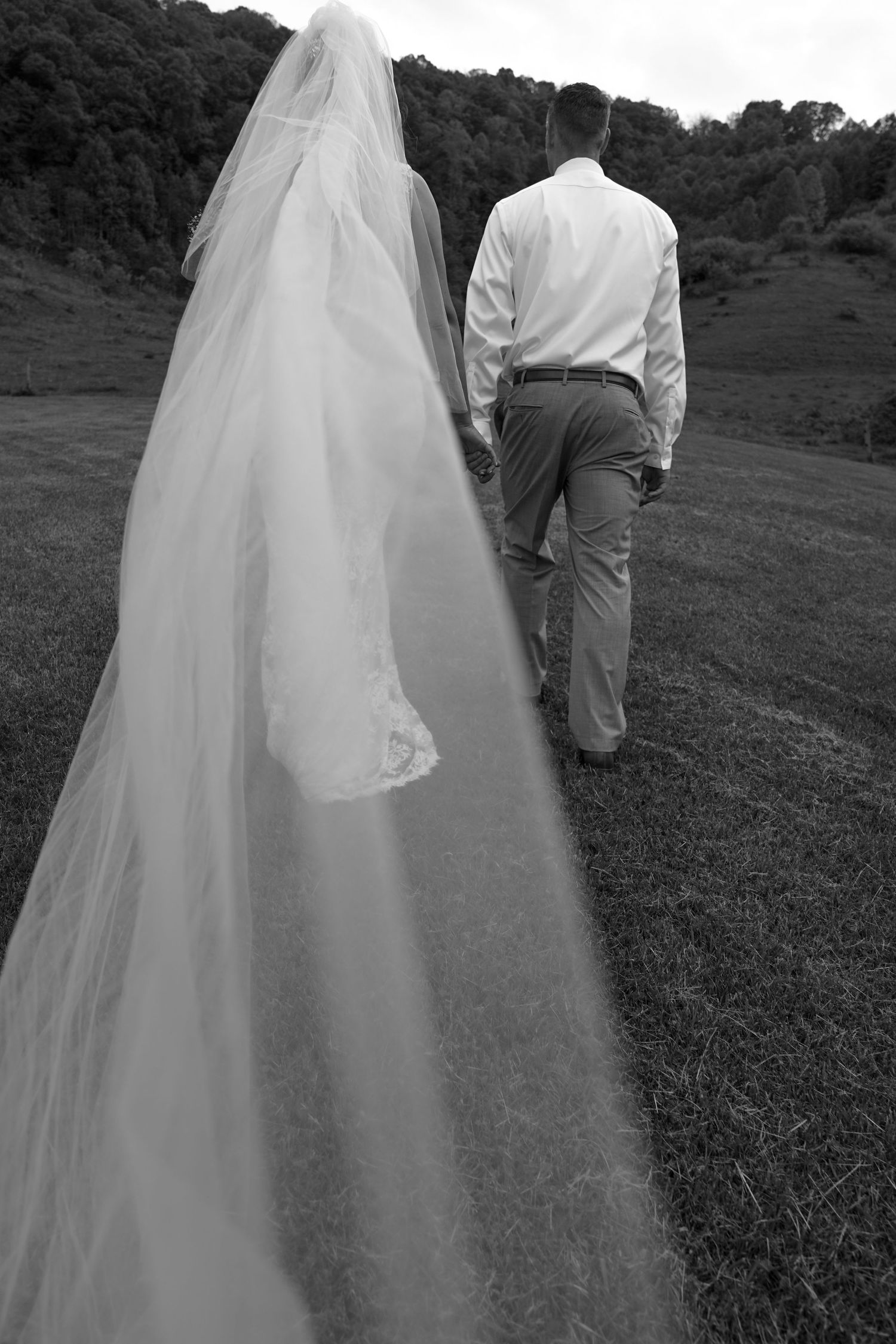 A black and white wedding photo sequence shows a couple walking away together on a grassy hillside.