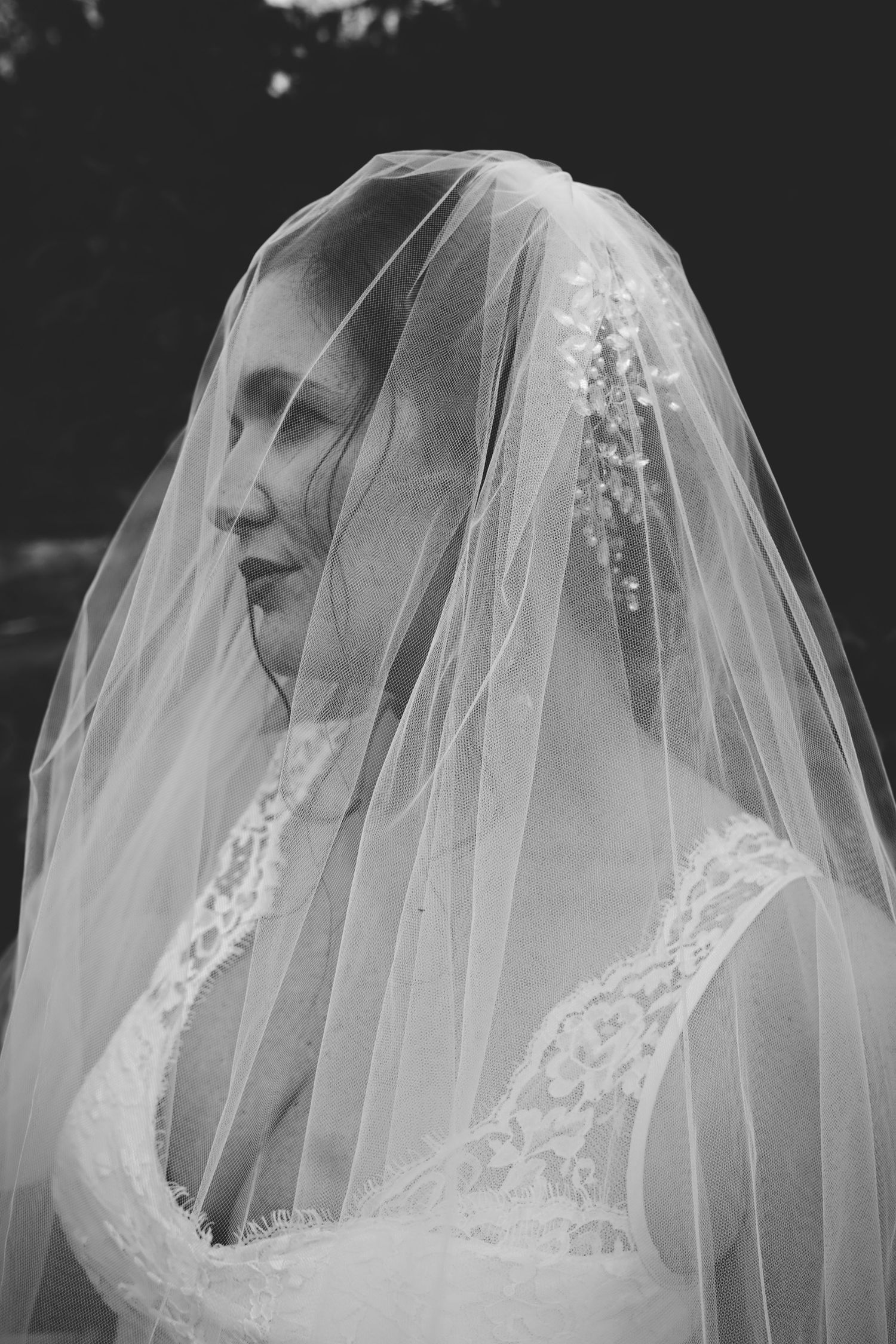 A black and white artistic series showing a bride in a delicate lace veil from different angles.