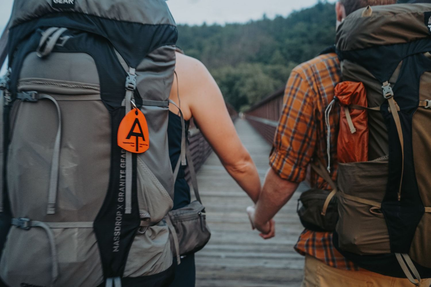 Group of hikers wearing backpacks walk together on a mountain trail during an outdoor adventure. Appalachian Trail Wedding Engagement