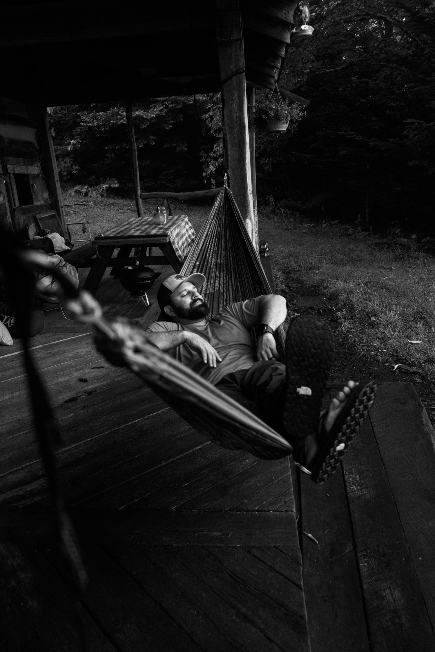 Dark moody shots of a hammock setup on a wooden deck at dusk.
