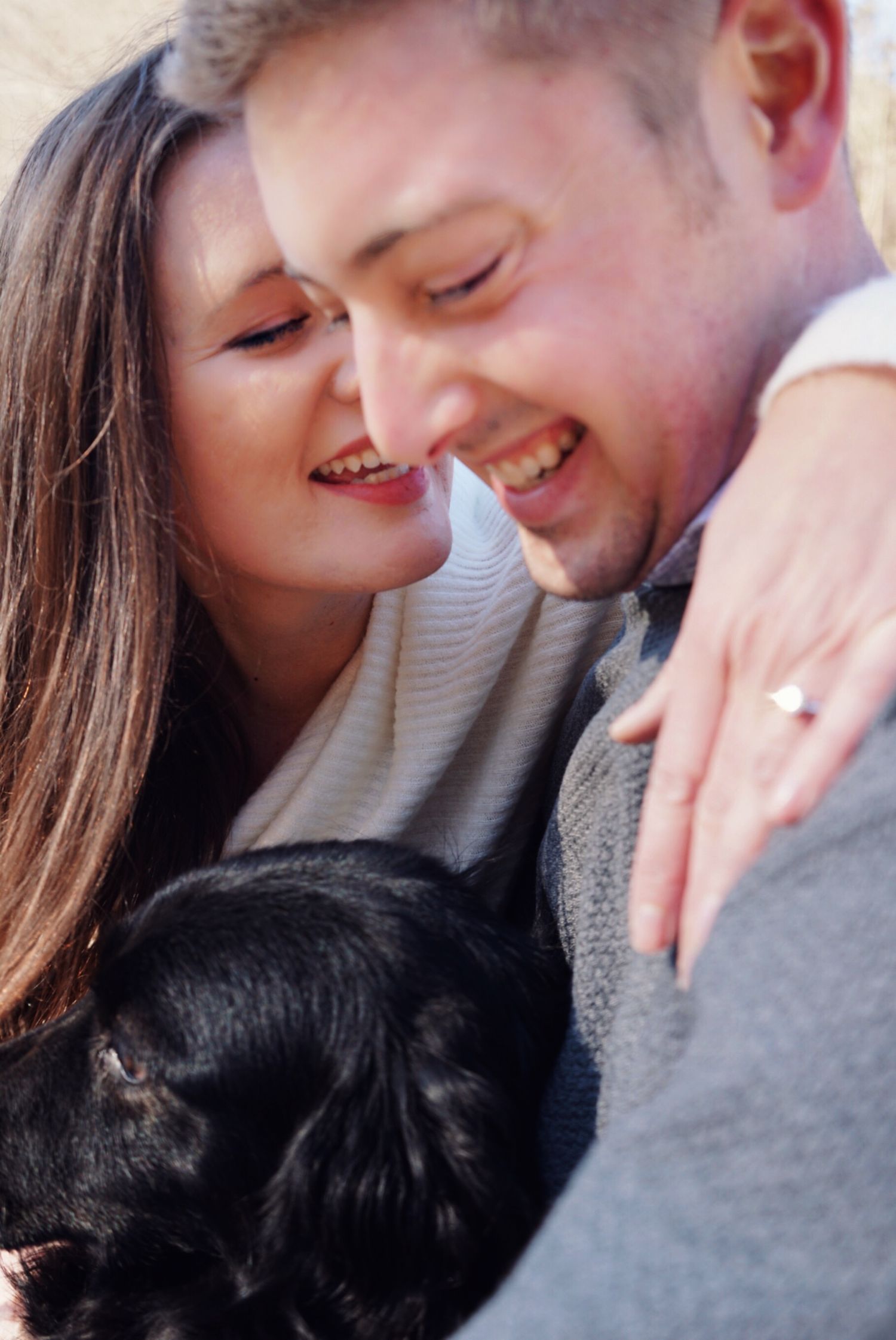 A close-up tender moment between two people with dark clothing in a natural setting.
