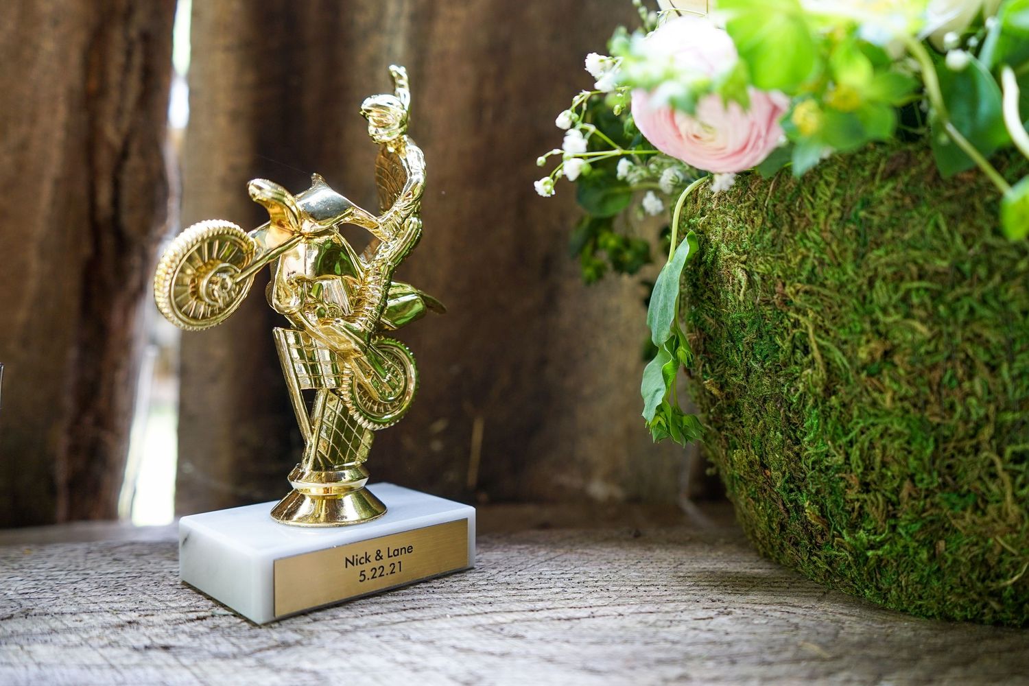 Elegant gold decorative elements and moss accents create a romantic garden-inspired wedding decor setting.