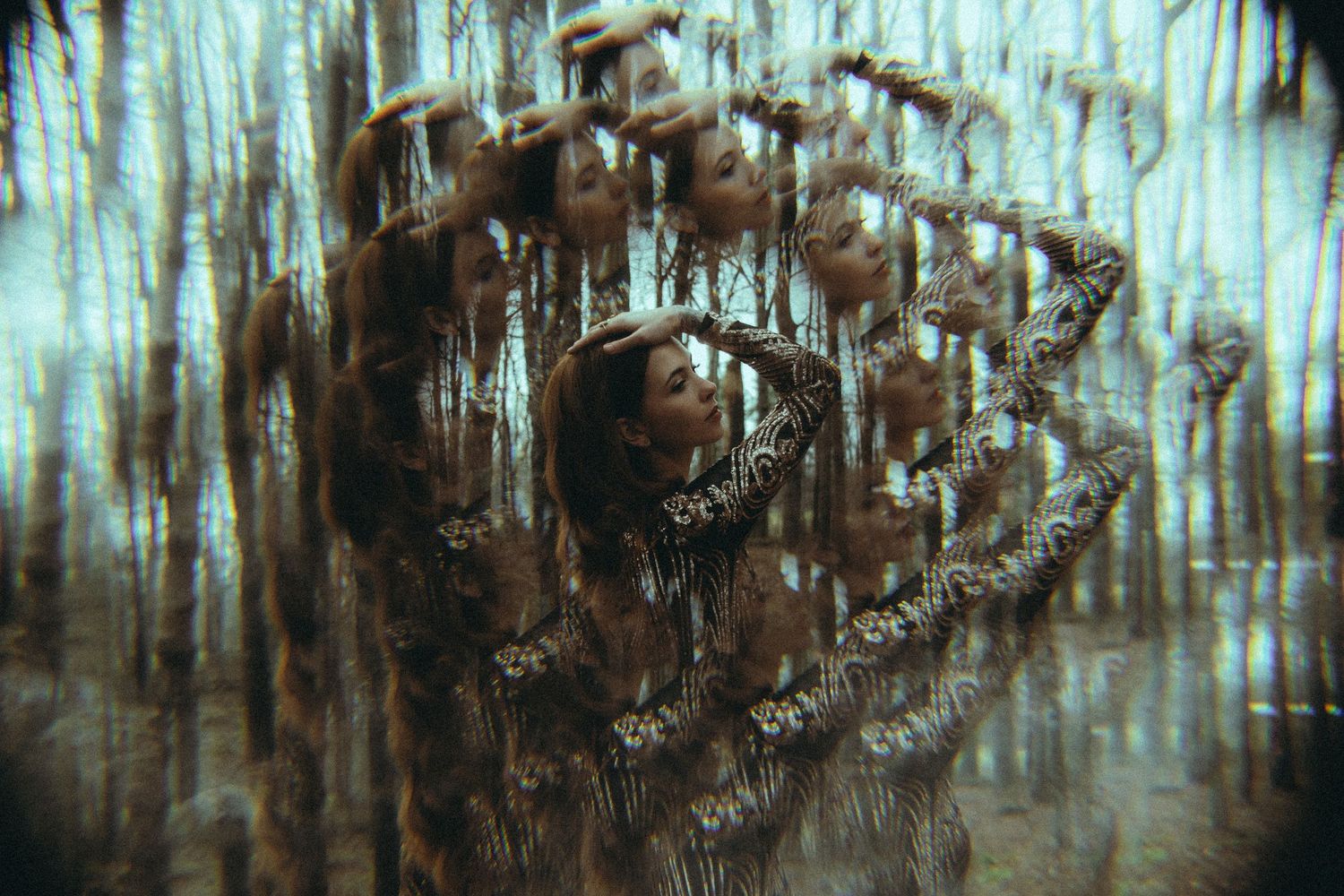 Surreal artistic photo of a woman surrounded by eerie hanging figures in a dark forest.