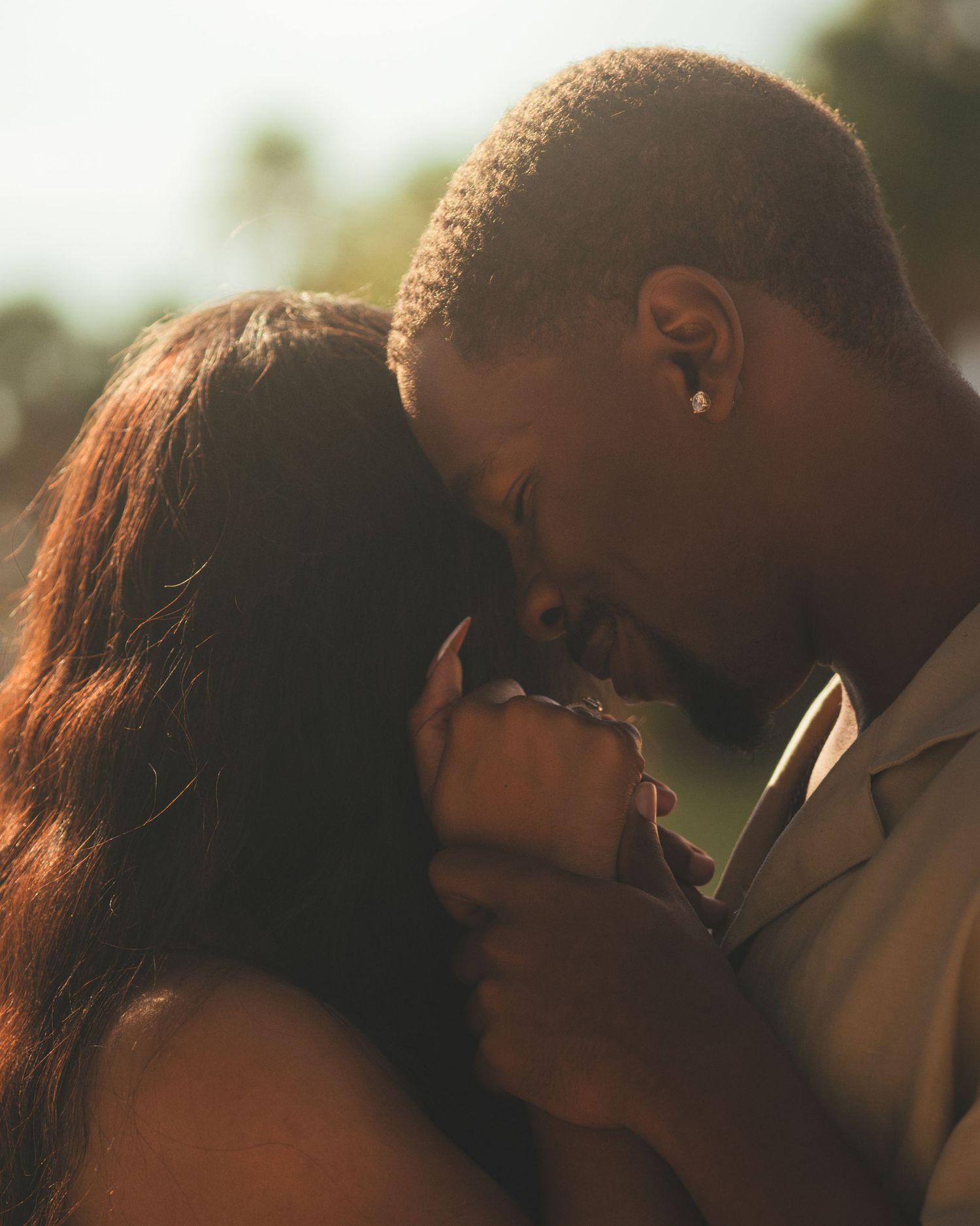 Romantic couple sharing an intimate moment at golden hour outdoors.