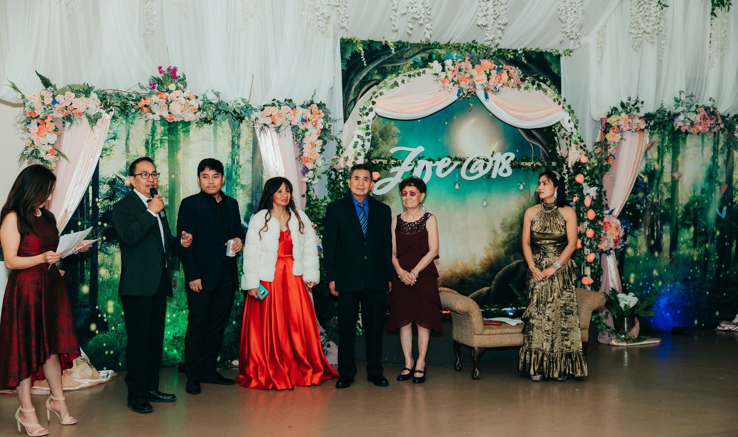 Wedding party gathering in an elegantly decorated venue with floral accents and soft lighting.