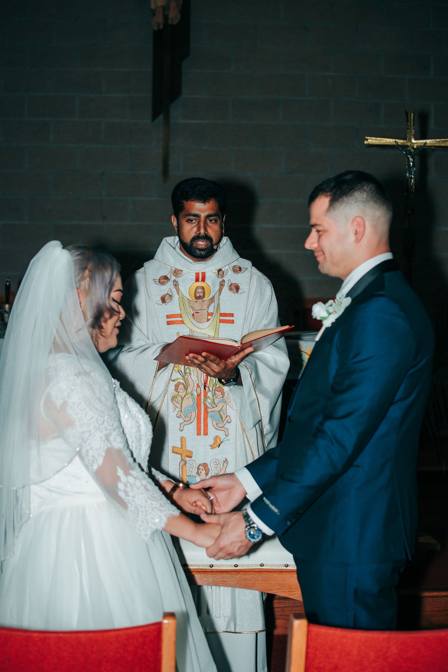 Religious wedding ceremony with priest officiating in traditional robes.