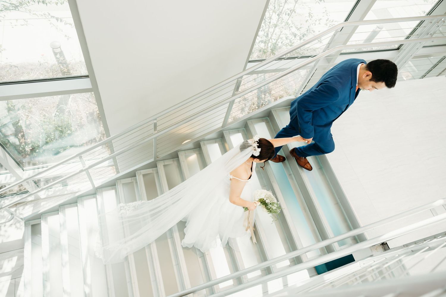 Couple in formal attire dancing in a bright modern venue with geometric wall decor.